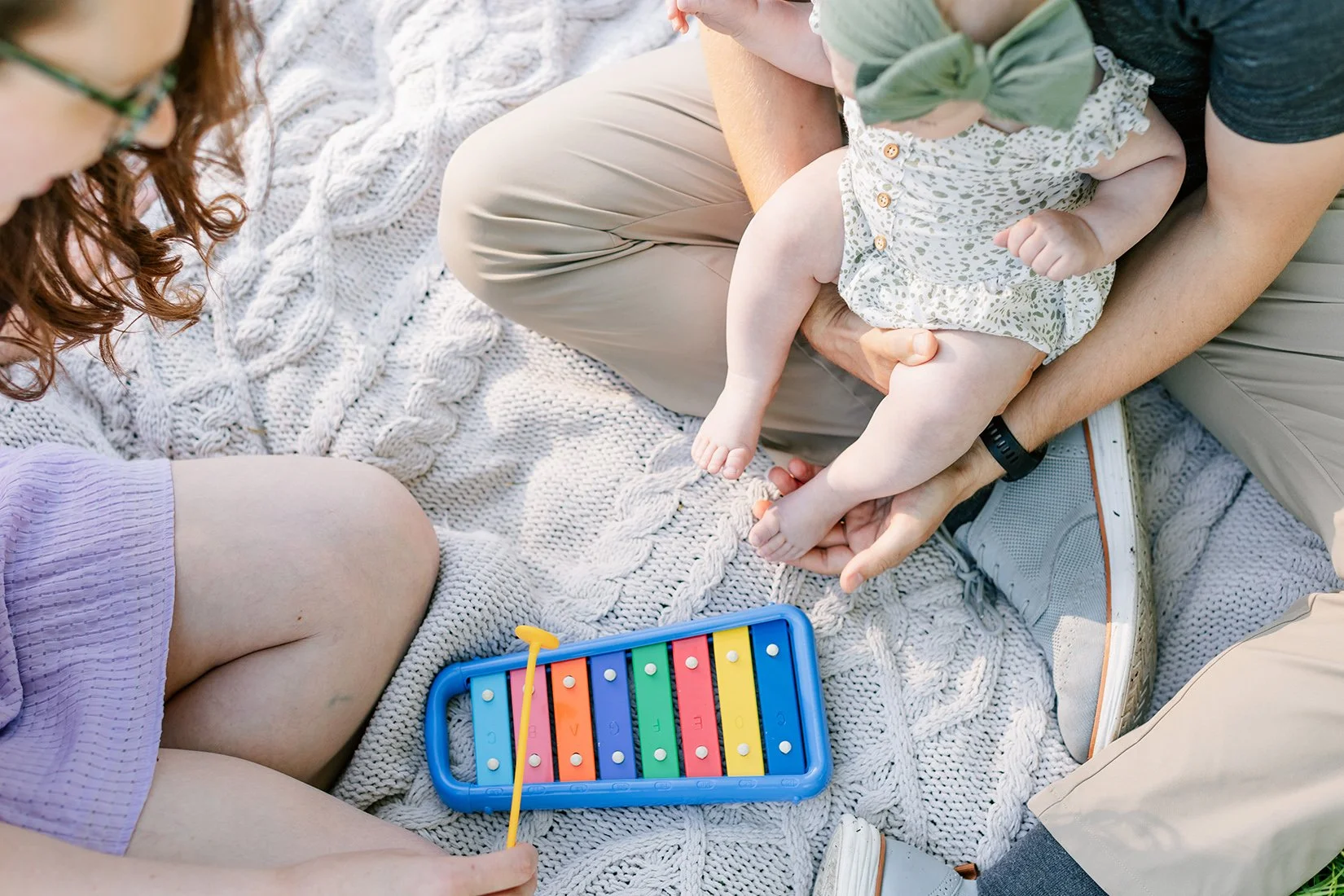 family playing with musical toys on blanket