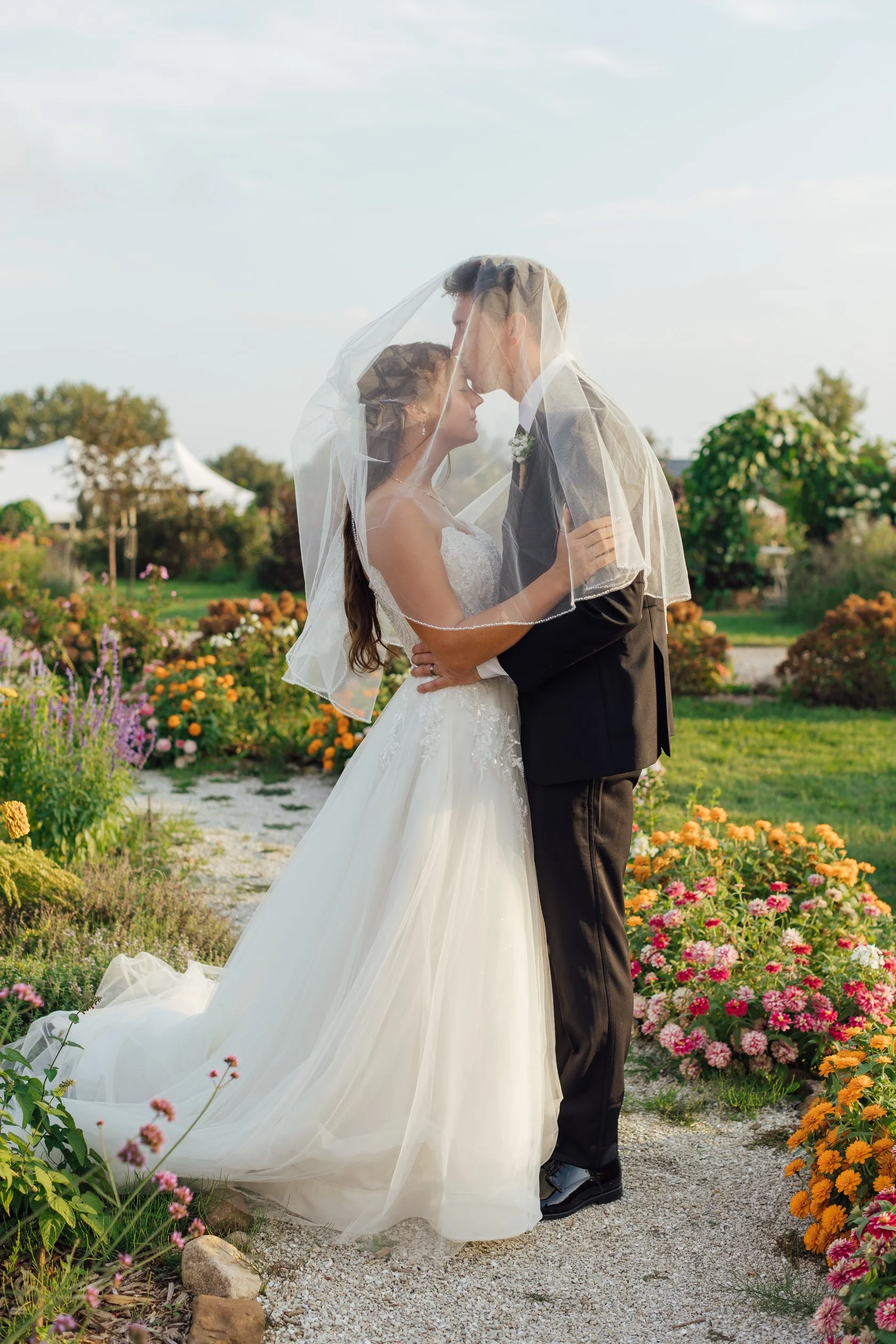 flower farm wedding Iowa groom kissing bride under veil