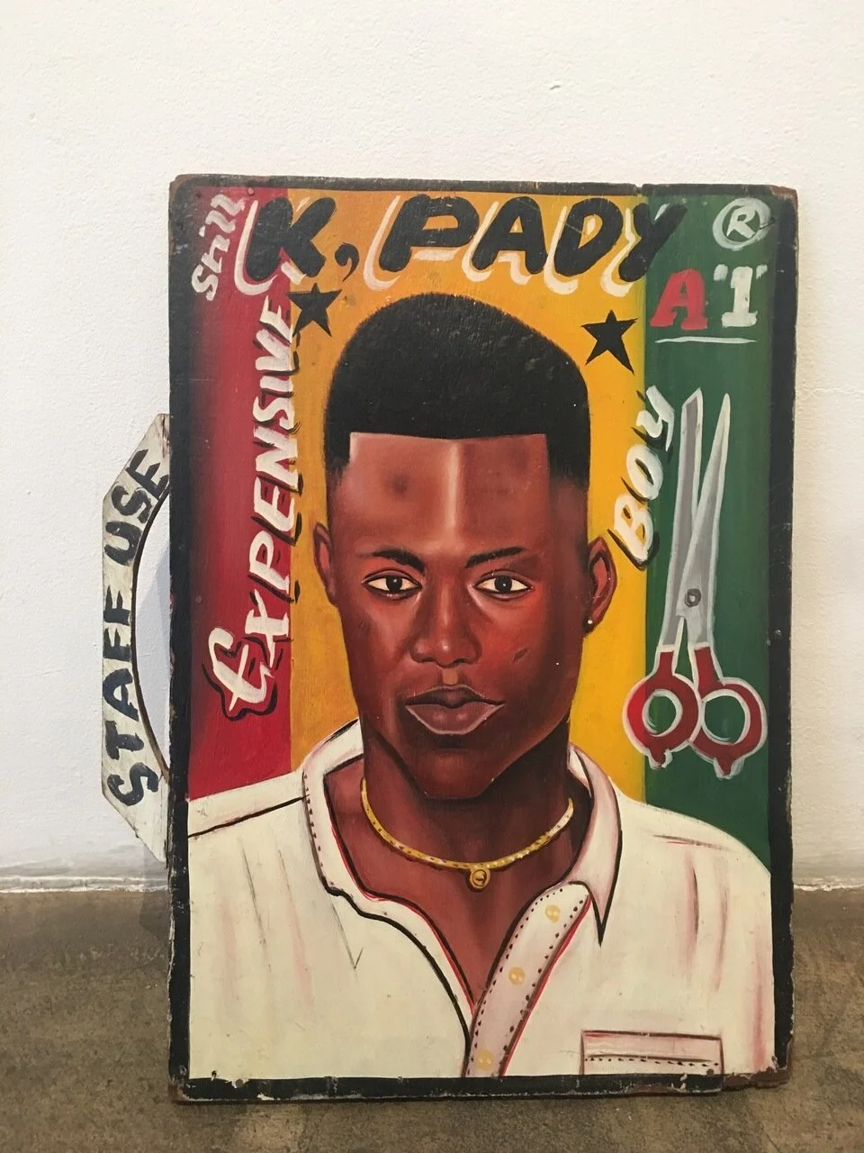 K Pady barbershop sign, c. early 1990s, Ghana, paint, wood, 21.5" x 15"