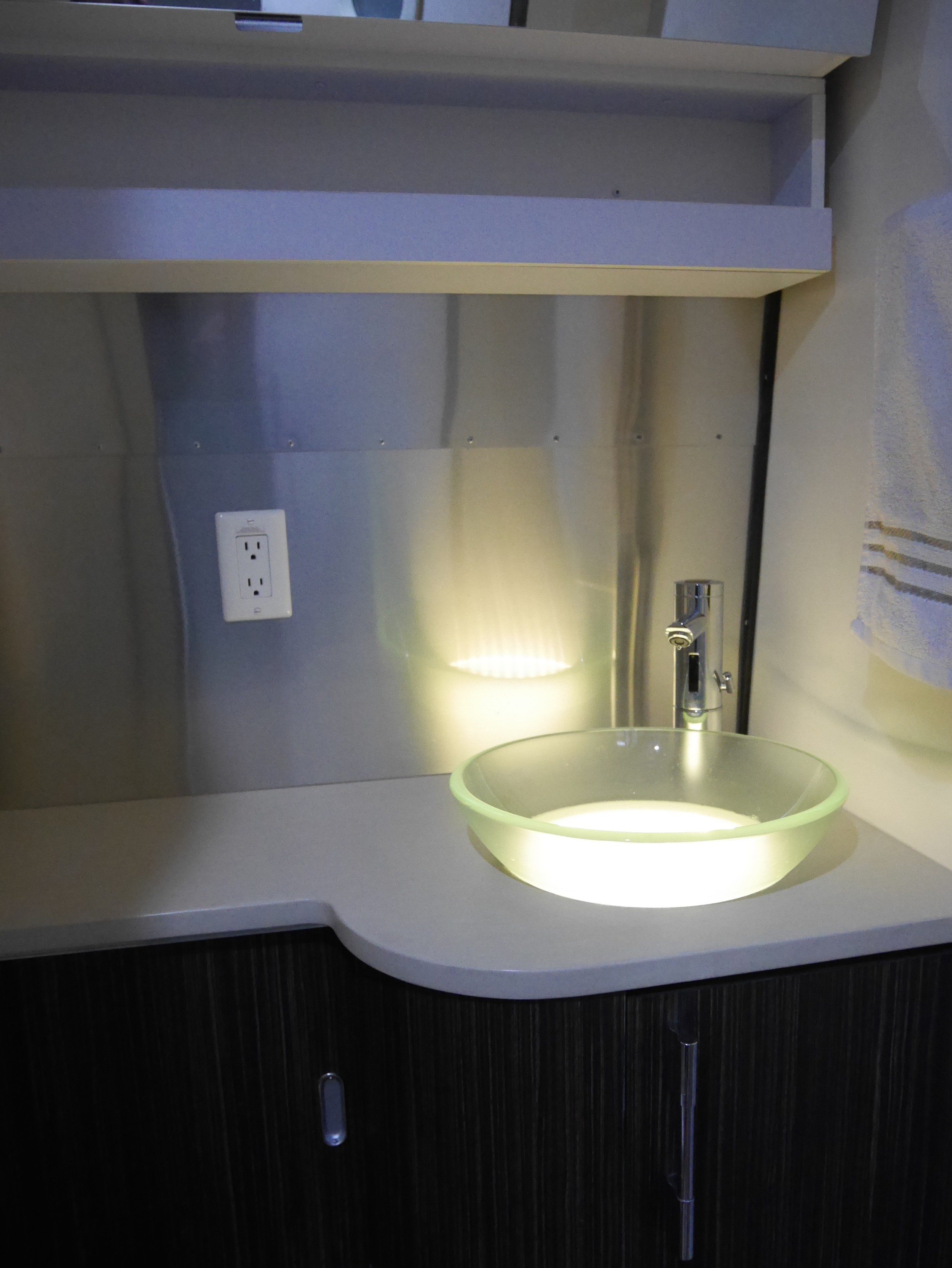 The automatic faucet really helps conserve water when washing your hands & face; the lighting is something we saw at the Four Seasons in Denver, and just thought was too cool not to do once we were going with a frosted glass sink.