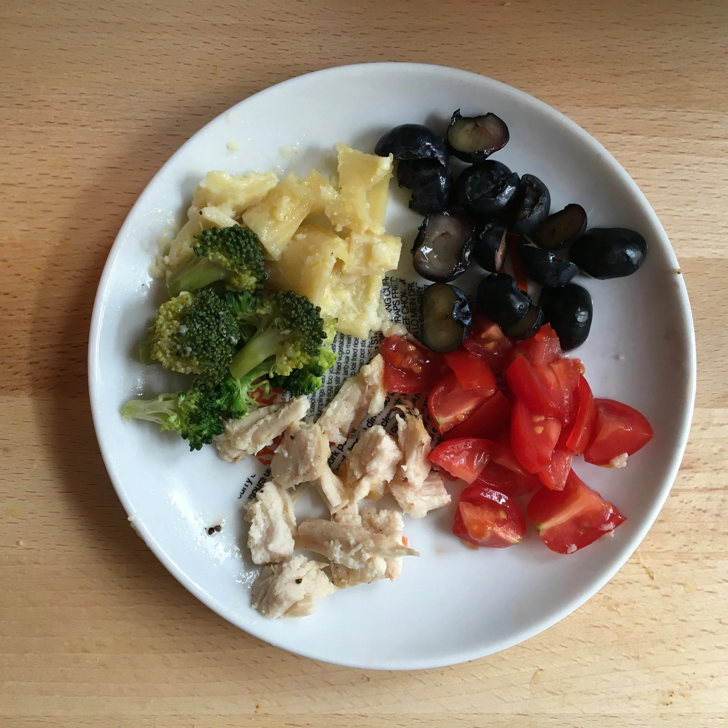 A meal for Ava at 10 months old: broccoli, leftover pasta with alfredo sauce, blueberries, tomatoes, and leftover chicken