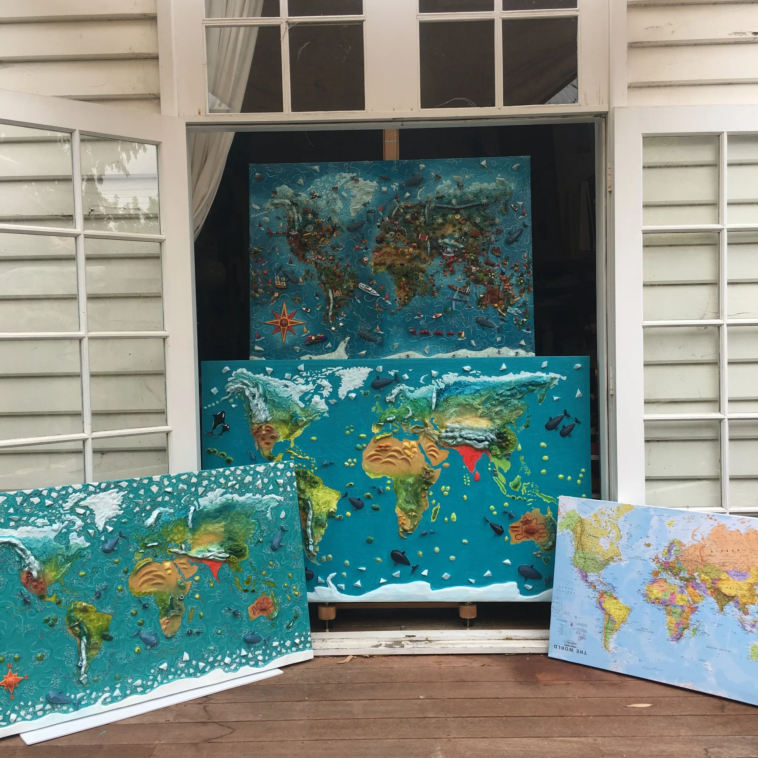 World maps in varying sizes and at different stages in the making process