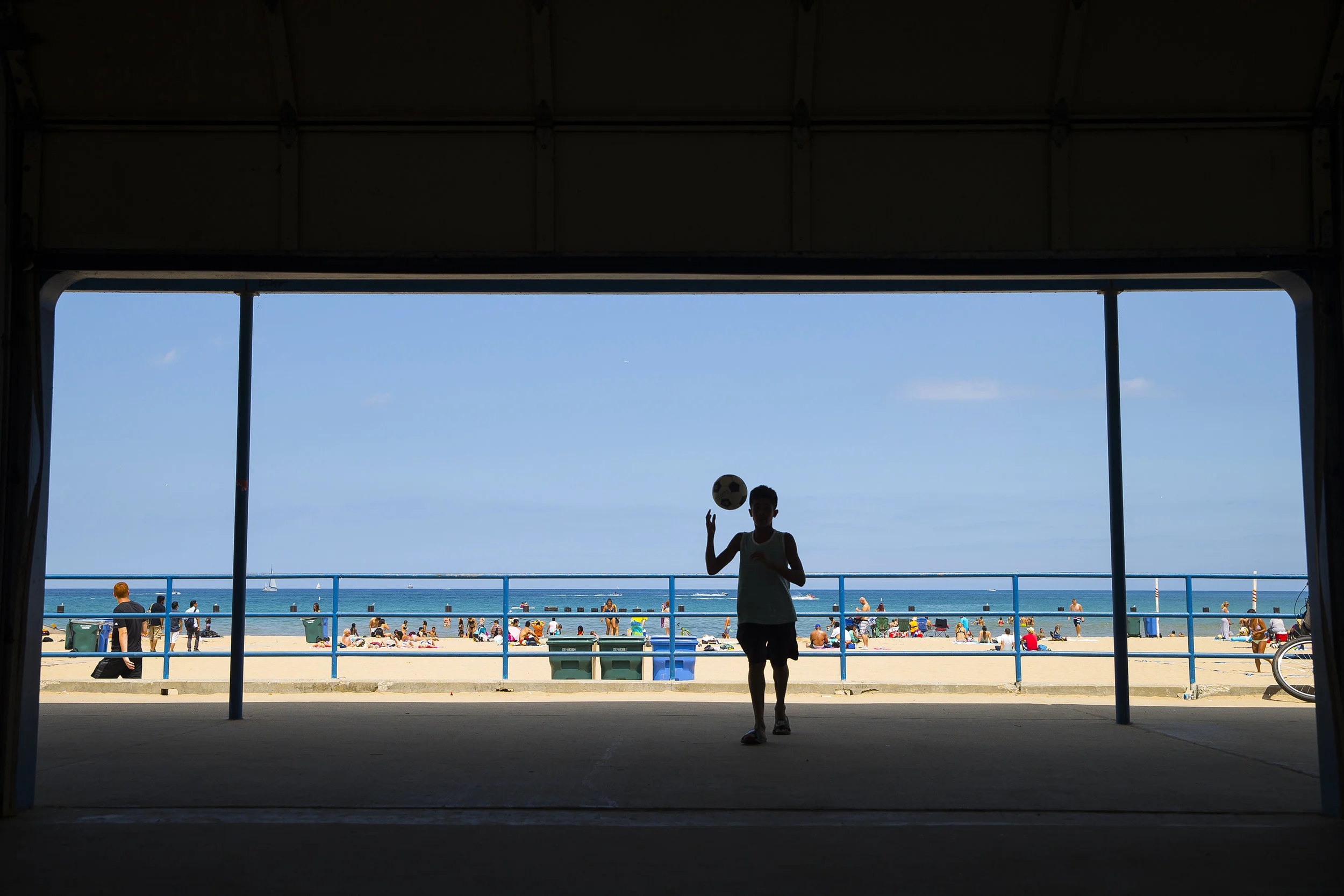  A kid is seen playing with a soccer ball at North Avenue bach Friday, August 5, 2016 in Chicago. 