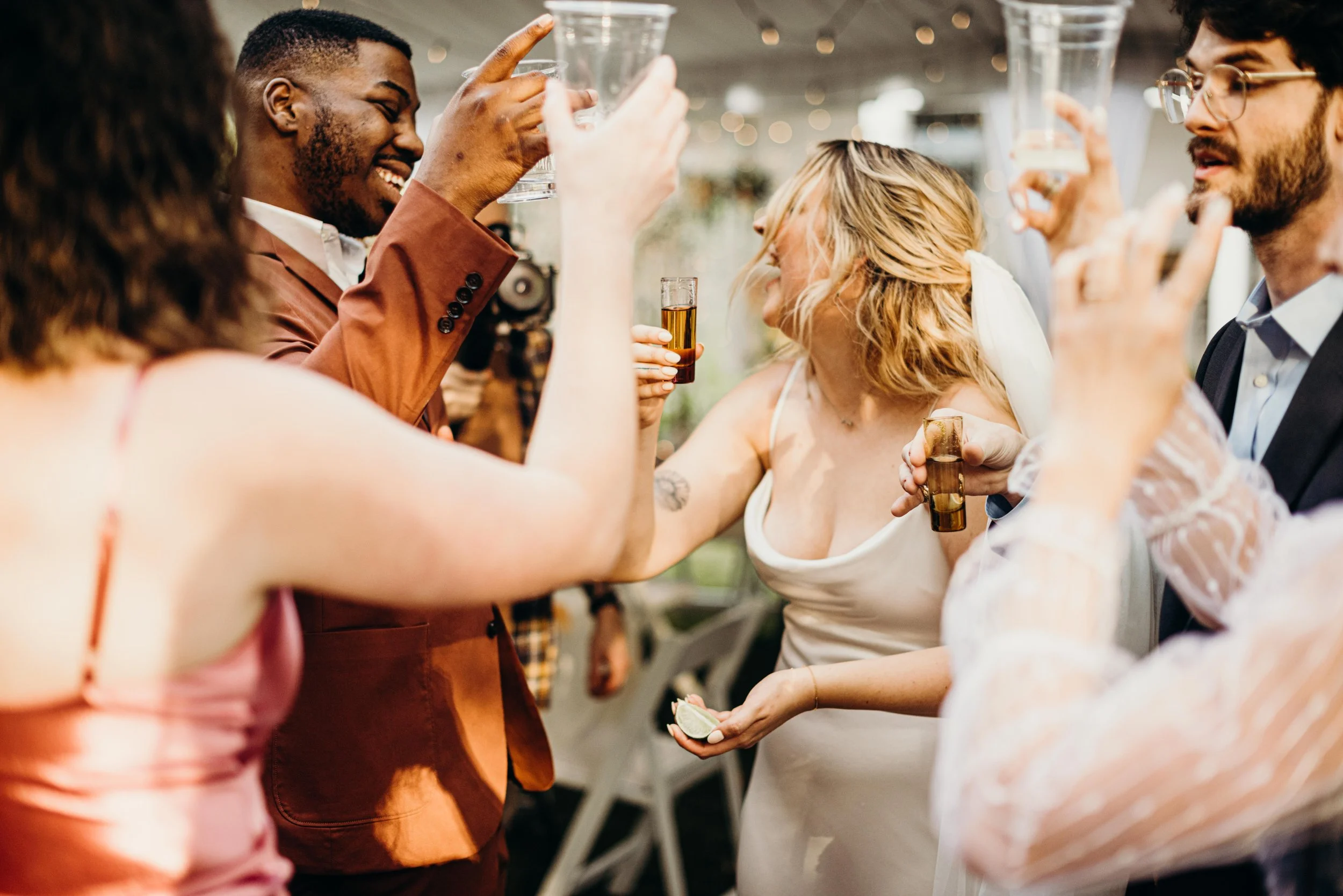 Group of people at a celebration raising glasses for a toast, smiling and engaging with each other.