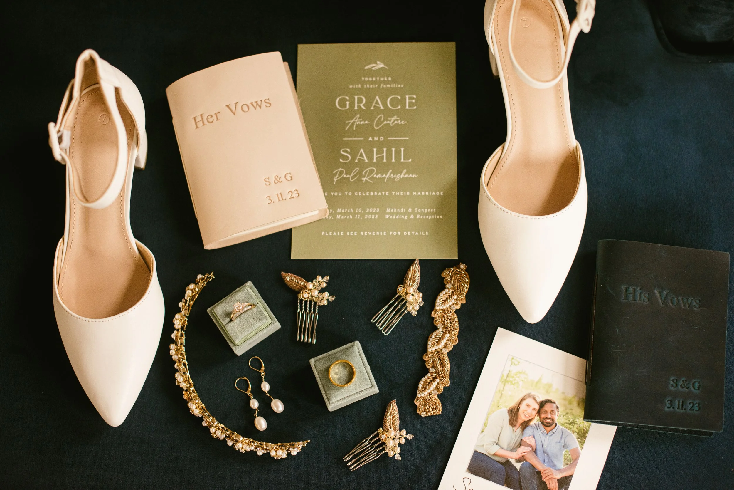Wedding jewelry including earrings, hair accessories, and a necklace, along with wedding shoes, a wedding invitation, a photo of a couple, and a small box labeled"Her Vows."
