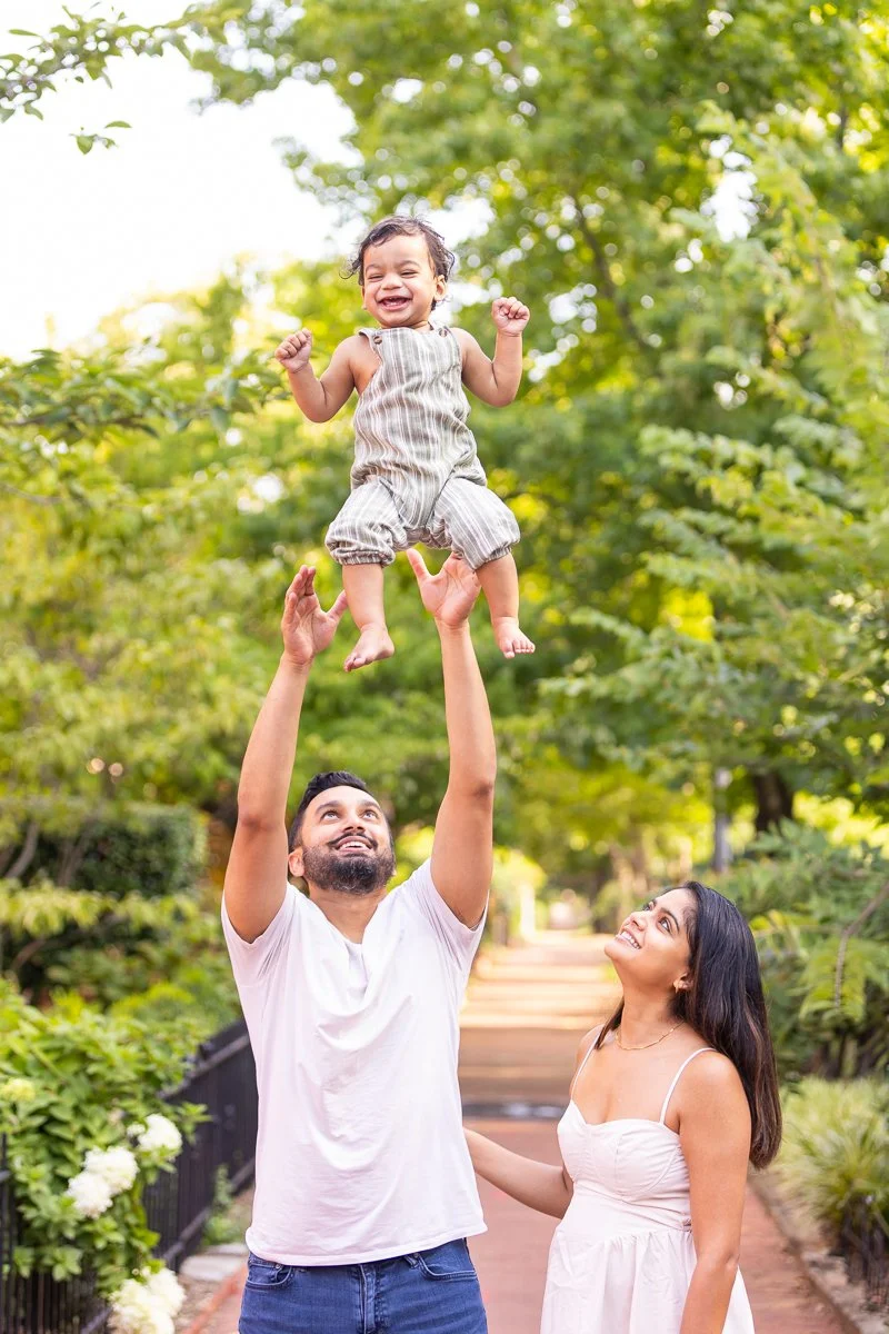 Outdoor family portrait of couple and baby playing together in the Capitol Hill neighborhood of Washington, D.C.