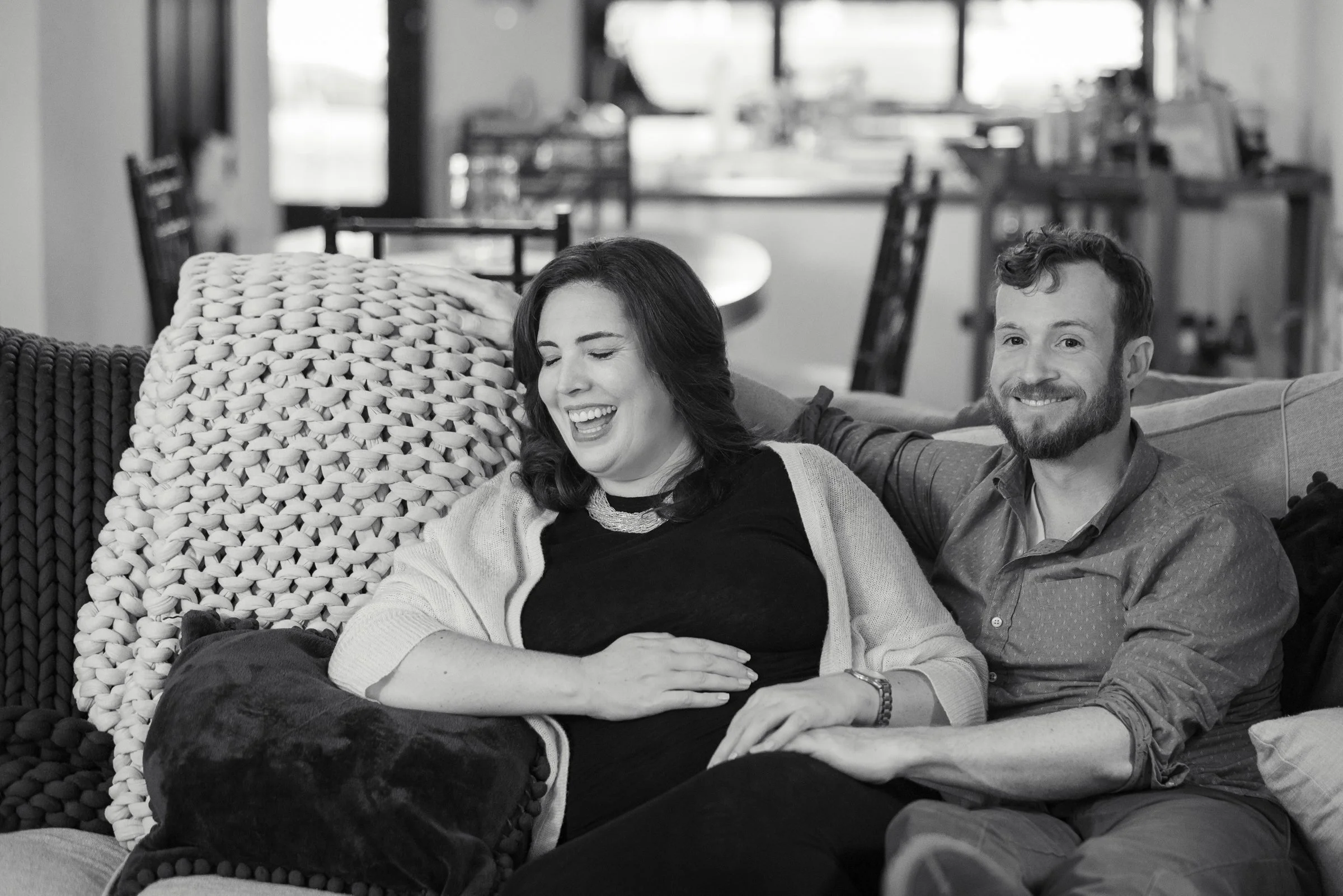 A smiling couple sitting on a couch in a cozy living room