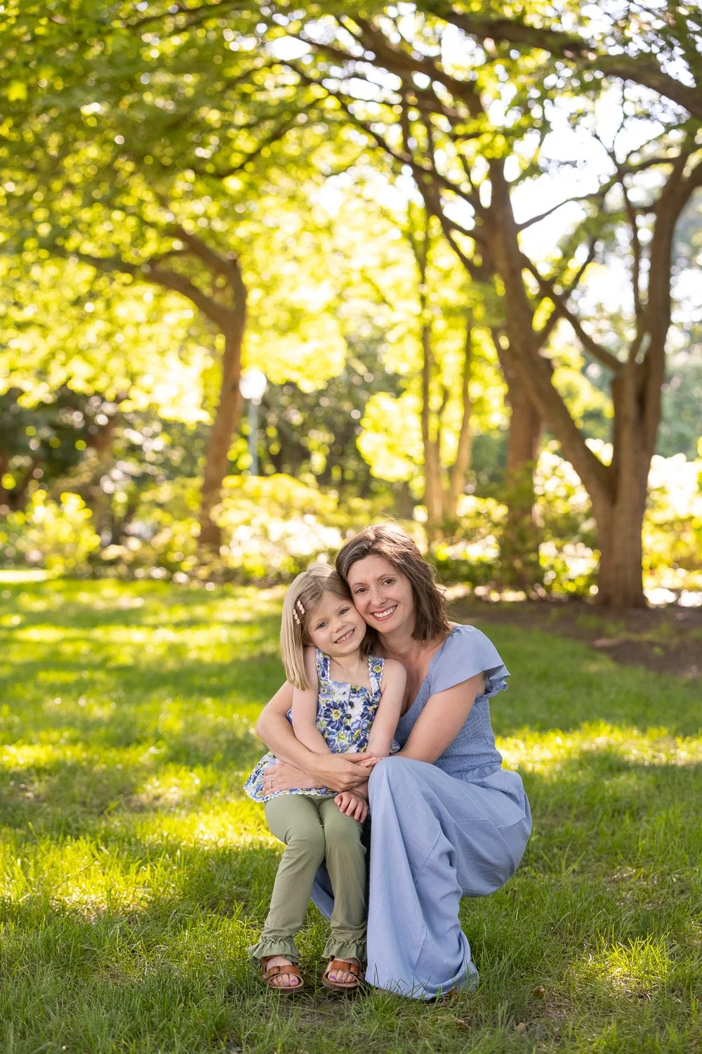 Outdoor lifestyle portrait of preschooler and mother smiling at the camera near the U.S. Capitol in Washington, D.C.