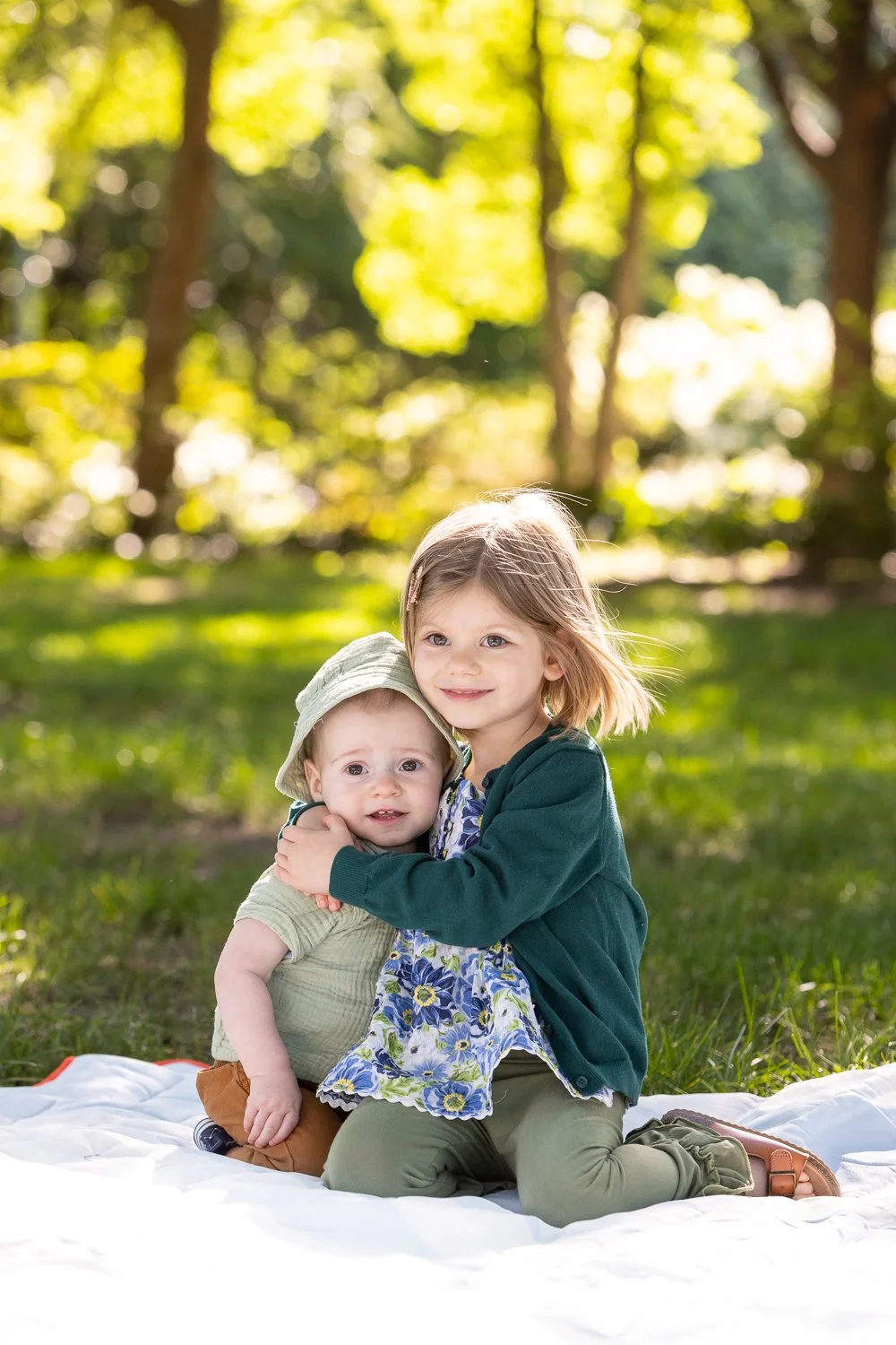 Portrait of toddler and preschooler hugging in the grass near the U.S. Capitol in Washington, D.C.
