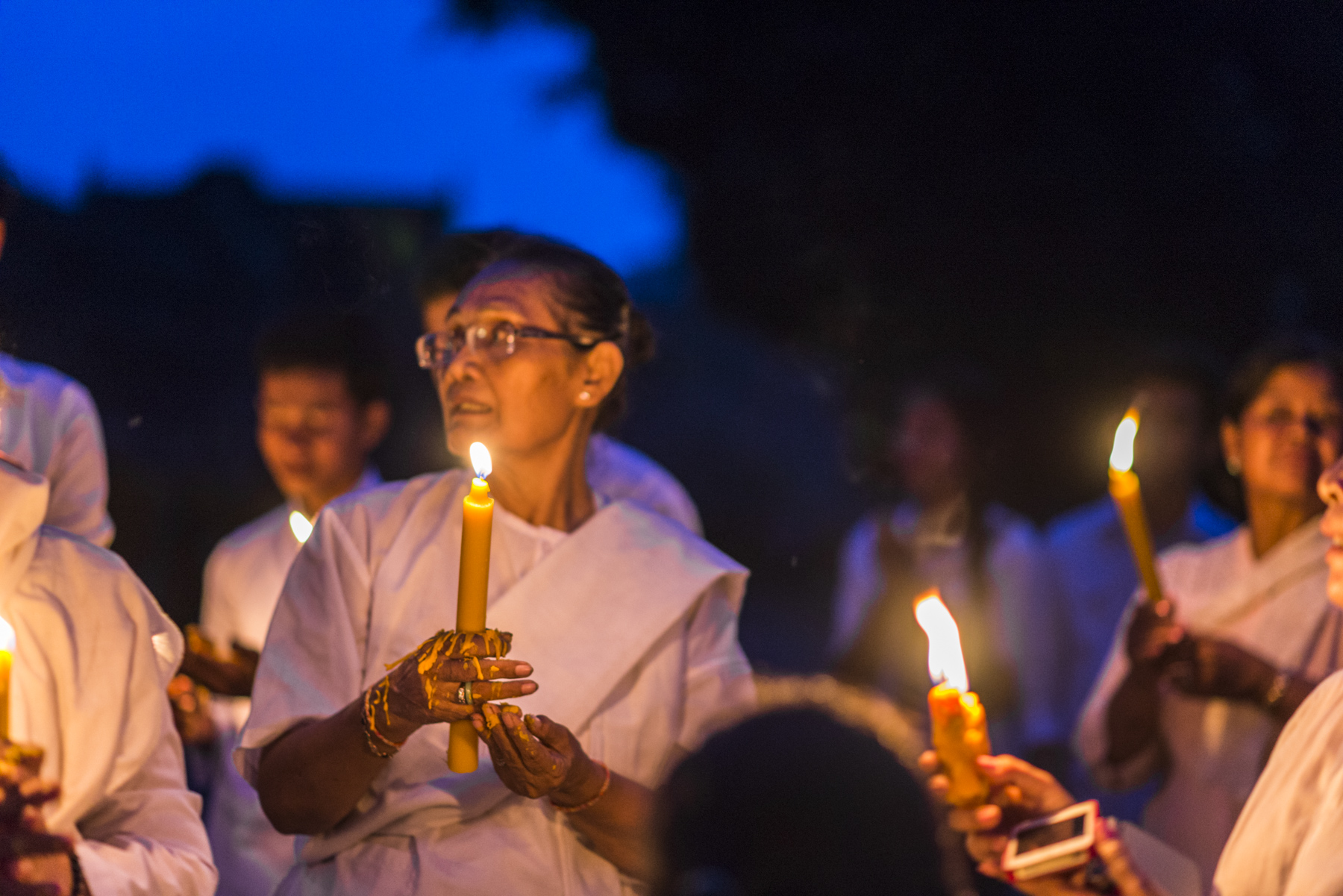 Wax dripping from a candle onto the hands of a nun as she holds it during the candle procession. 
