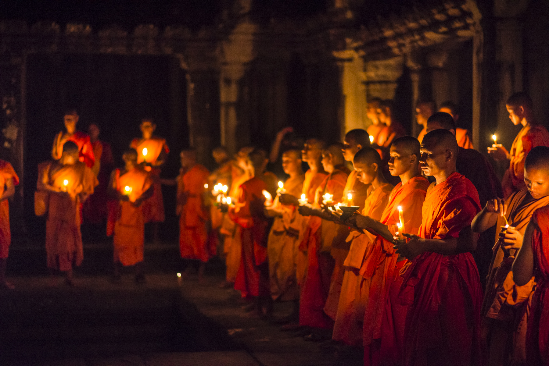 Monks holding candles as they gather in the Gallery of 1,000 Buddhas at Angkor Wat.