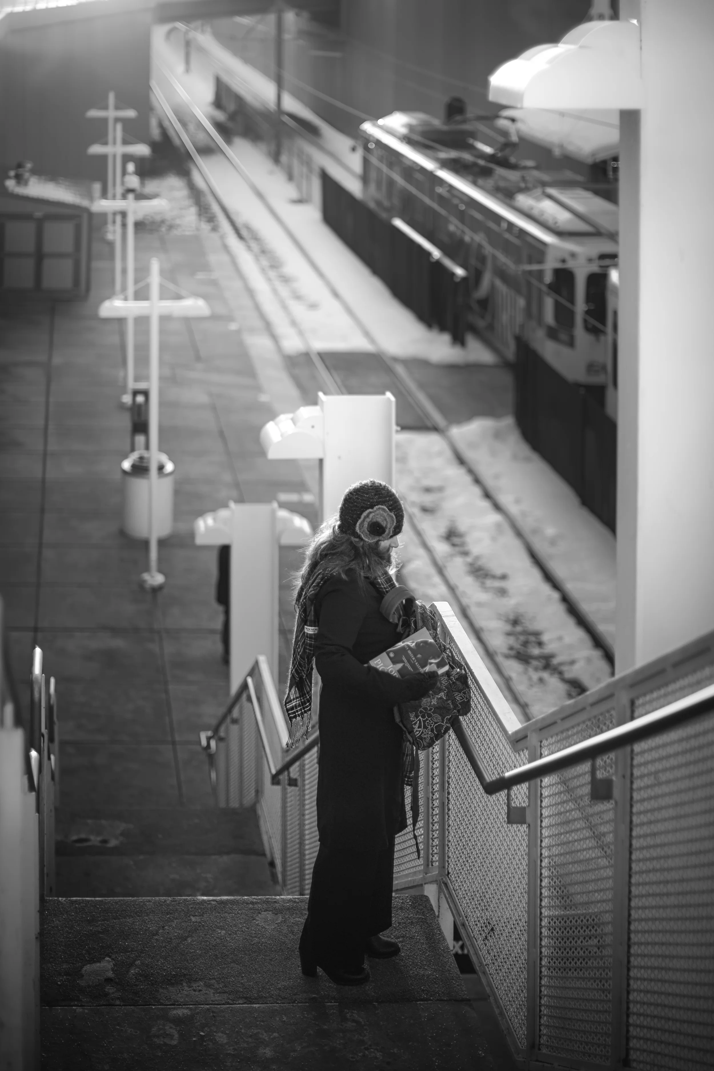 A women standing on the stairs at the train station.