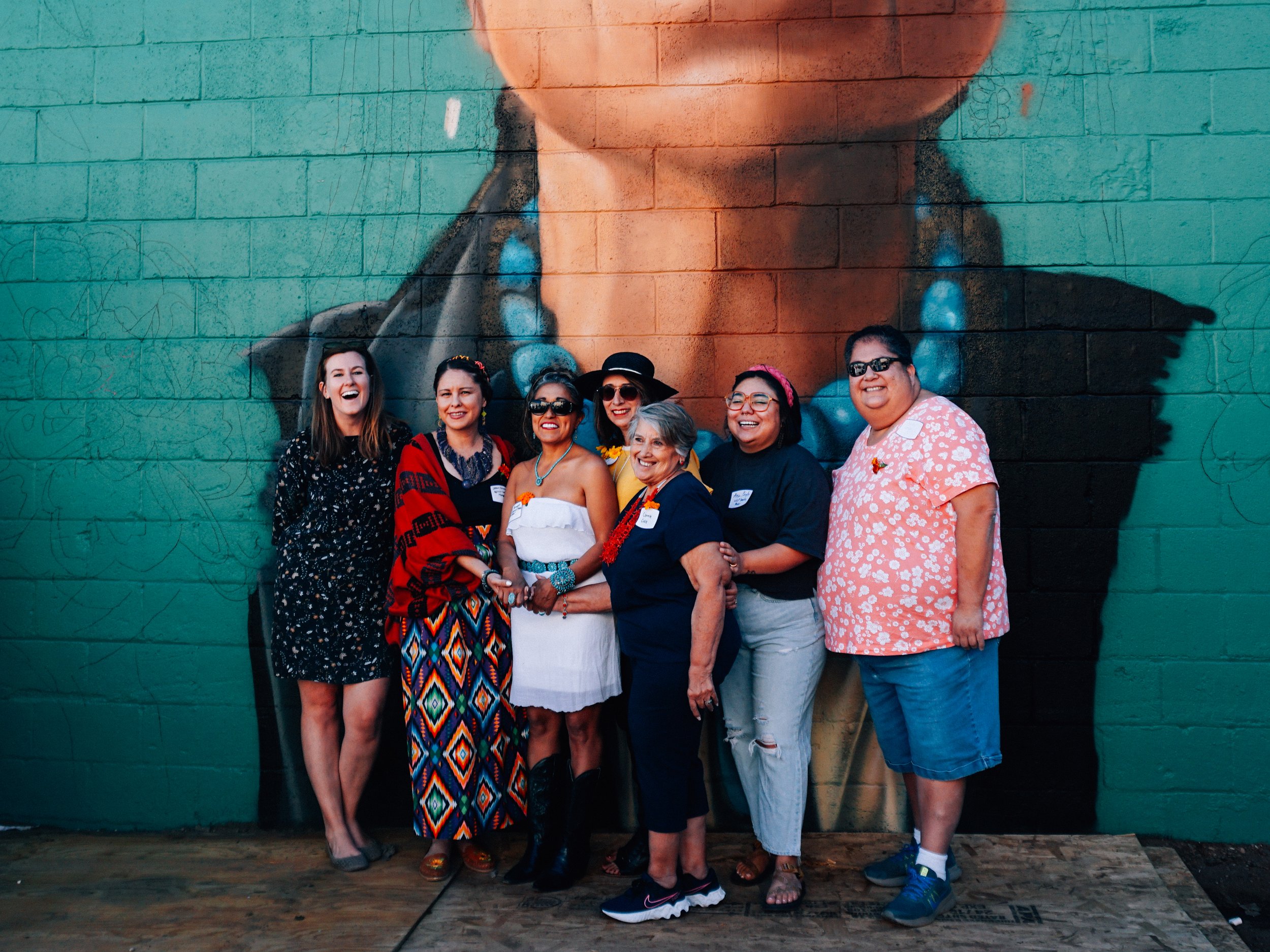  Members of the mural committee with the in-process artwork. Image by Luna Photography. 
