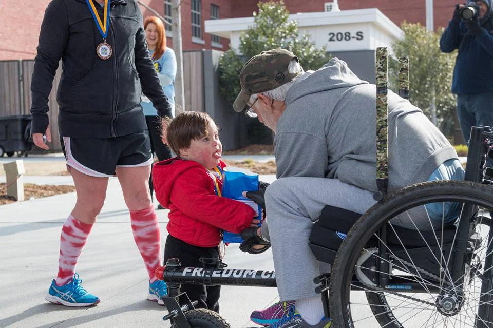 "Me being awarded my 1st in age group . . . last Saturday. The race was a fundraiser for a local Down Syndrome support group . . . It was my best time yet and being presented the award by such a cute little guy was icing on the cake." - John Hollis