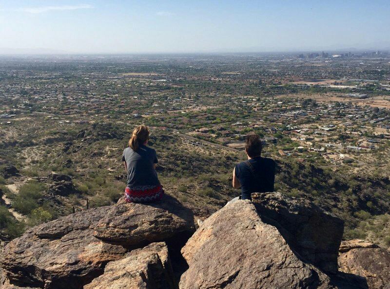 Sitting on the edge of a cliff overlooking Phoenix metro area with a colleague (the rest of our group was just to the side and behind taking this pic)