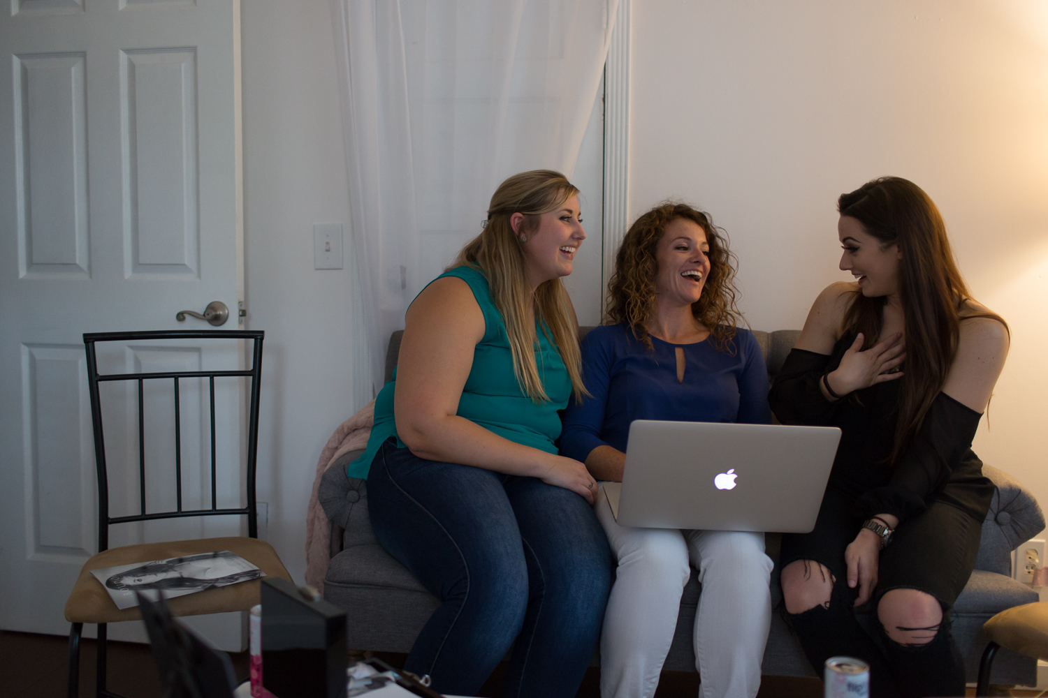 Girls sitting on couch laughing together