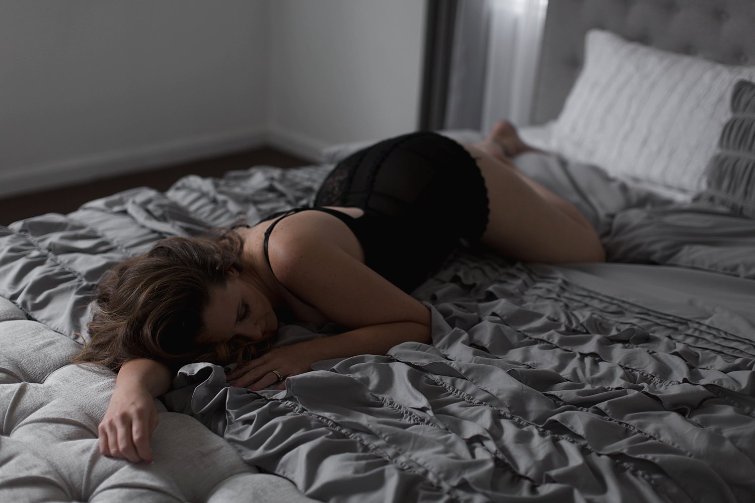 Woman laying in bed wearing black babydoll