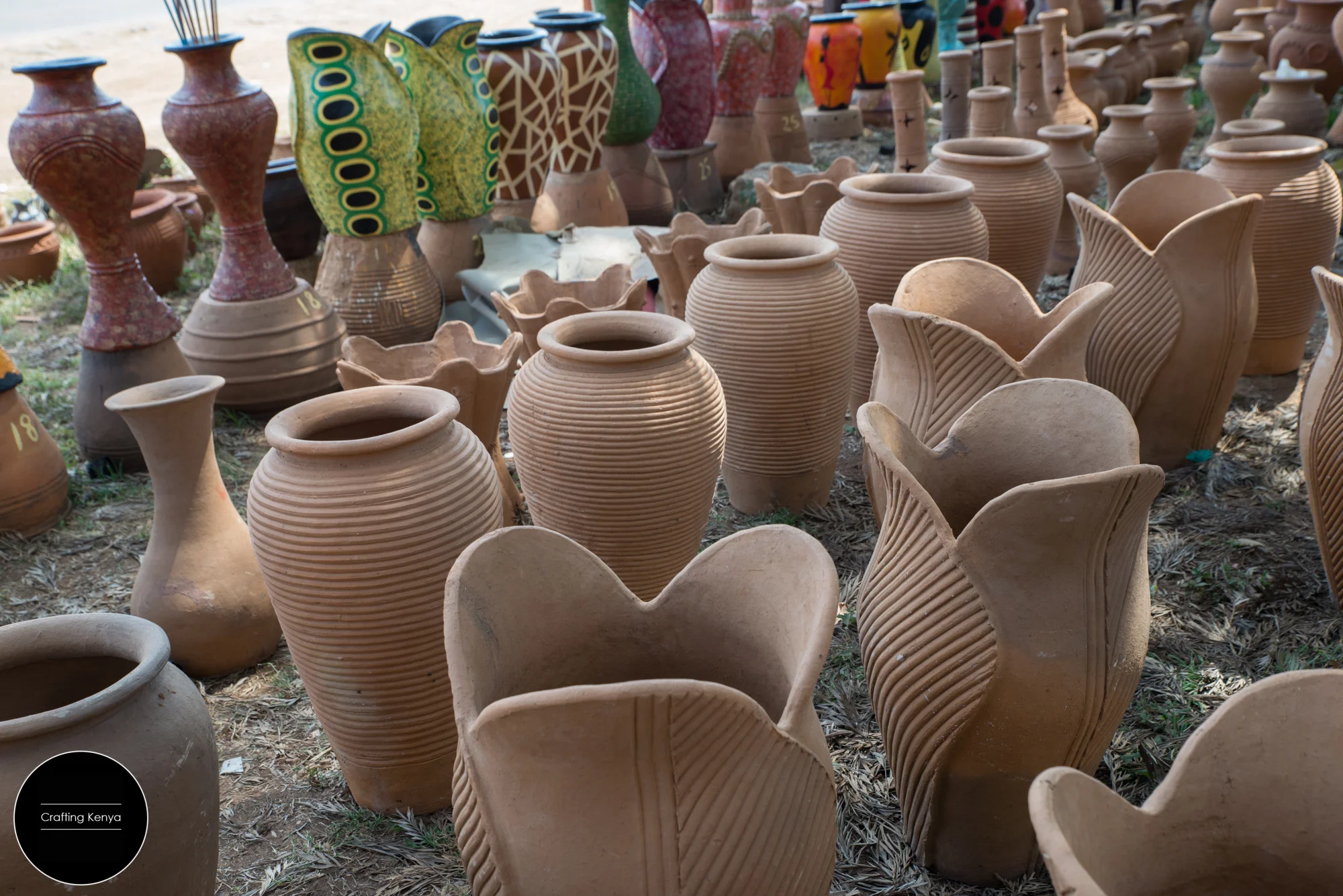 Kiln-fired clay pots lined up for painting