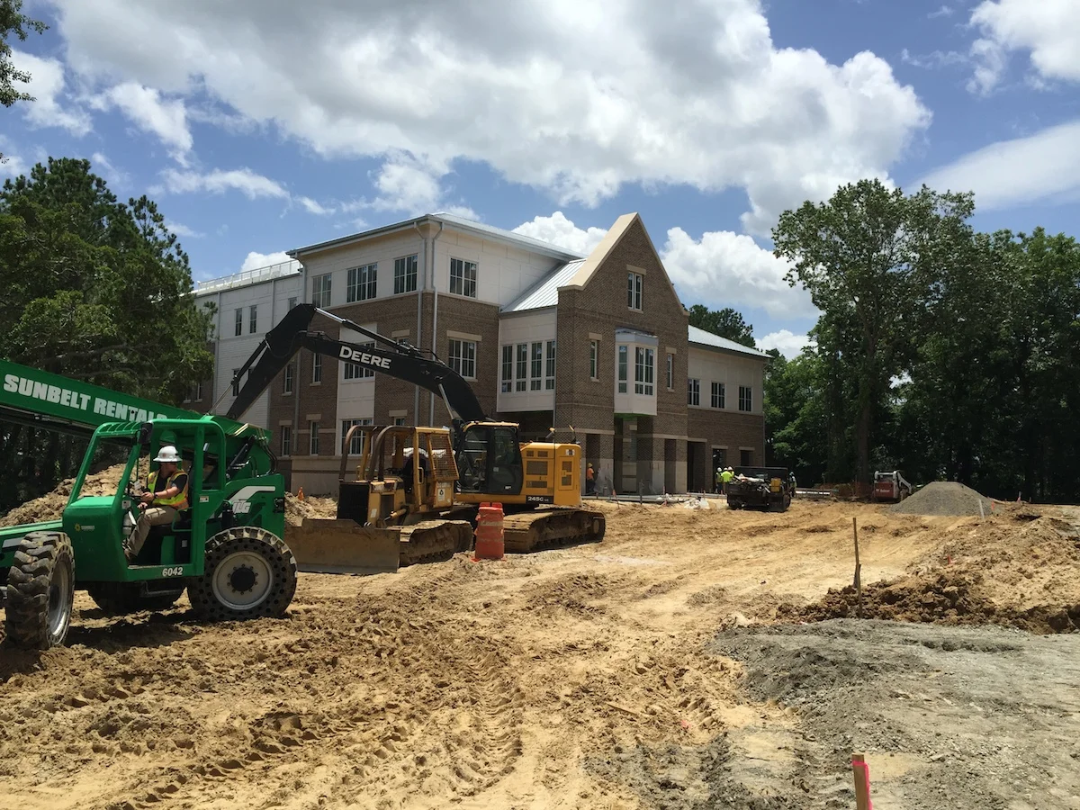 Exterior construction photo of office. The main entrance is at the base of the gable in the front.