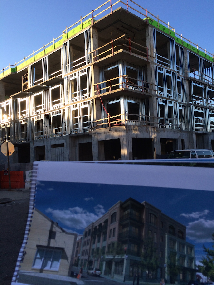 Construction photo of The Spectator with me holding up the rendering in the foreground.