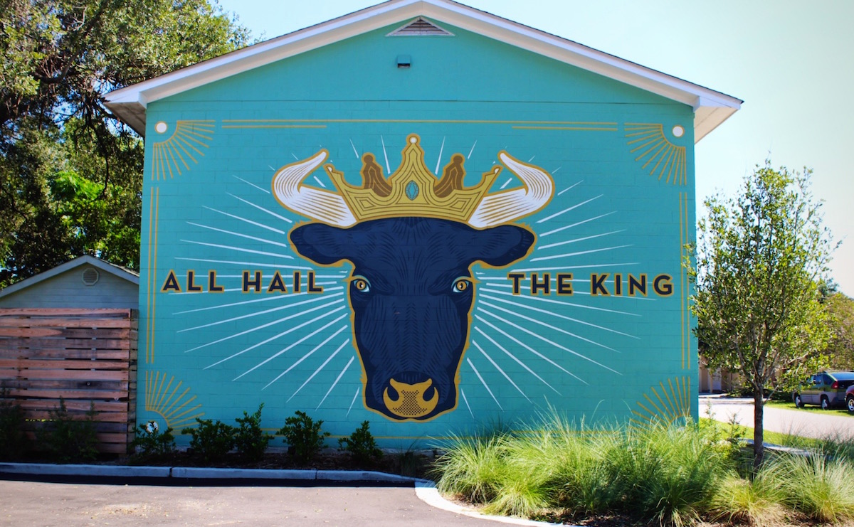 The Cow King mural is a part of the Lewis BBQ complex. Limelight Custom Sign Company painted the sign from a design by Scott Harrell.