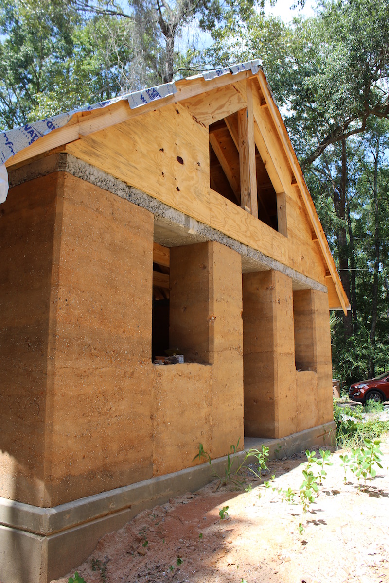 The Walters Residence. The exterior walls are rammed earth up to the top of the windows where there is a continuous concrete header. The walls sit on a concrete foundation. Photo Credit: Danielle Ramos