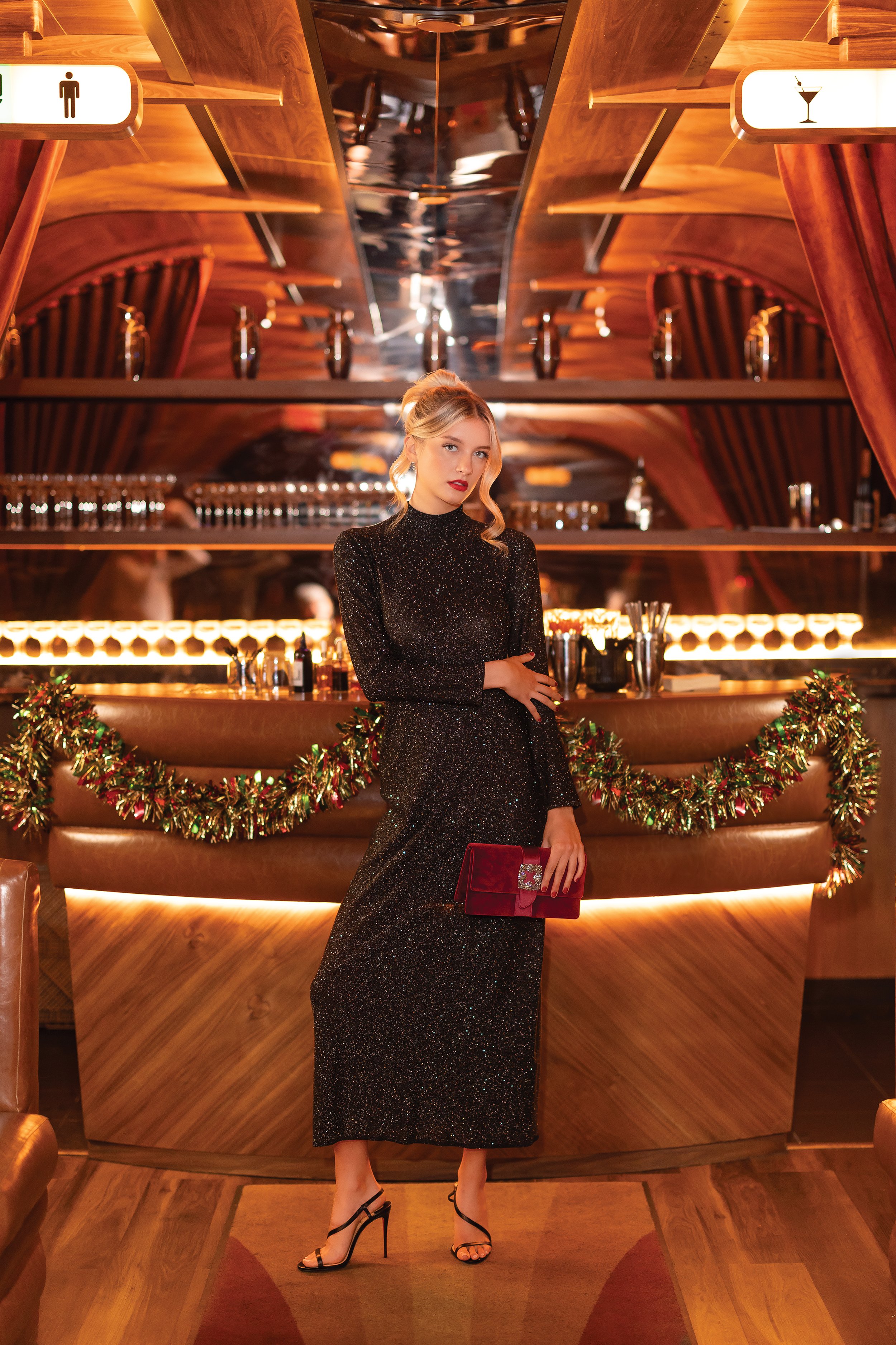   DRESS:  Black sparkly long-sleeved maxi, Oscar de la Renta, $3,890.  HANDBAG:  Red velvet clutch, Manolo Blahnik, $2,045.  SHOES:  Black sandals, Christian Louboutin, $845. All from Wunderkind,  shopwunderkind.com  