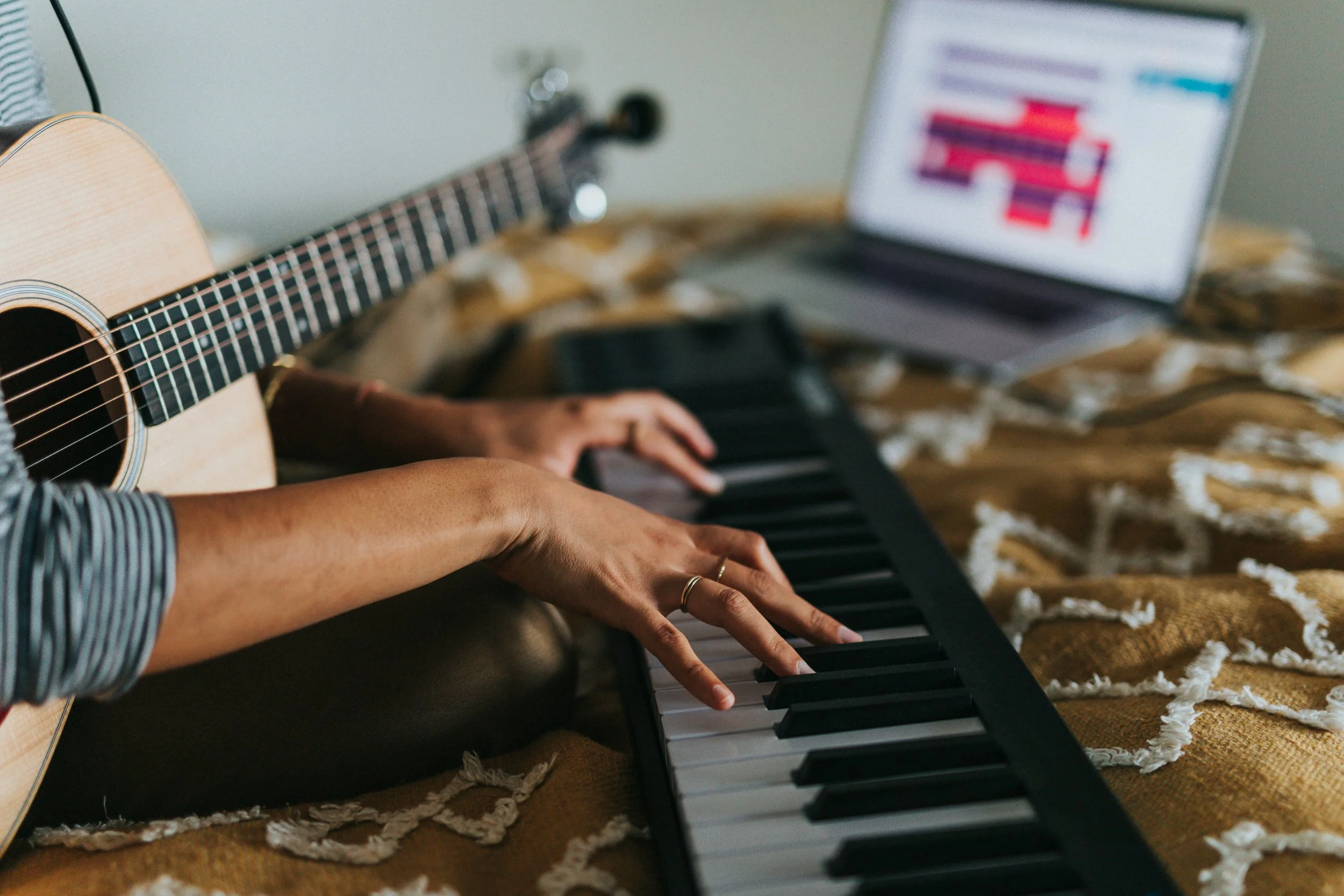 a person playing piano with a guitar in their lap
