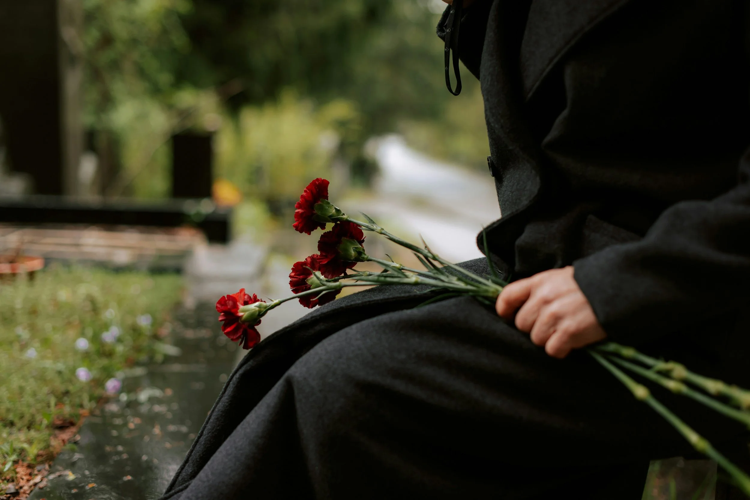 woman holding flowers at cemetary