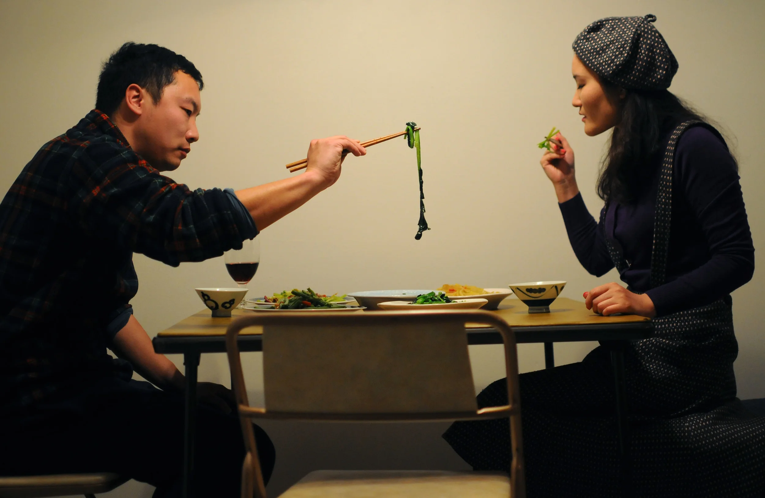   From left, Kai Qiao and his wife Yang Wang eat dinner in their new apartment on Wednesday, March 5, 2014. A couple of the dishes included a spicy beef and celery stir fry and hot and sour shredded potatoes.  