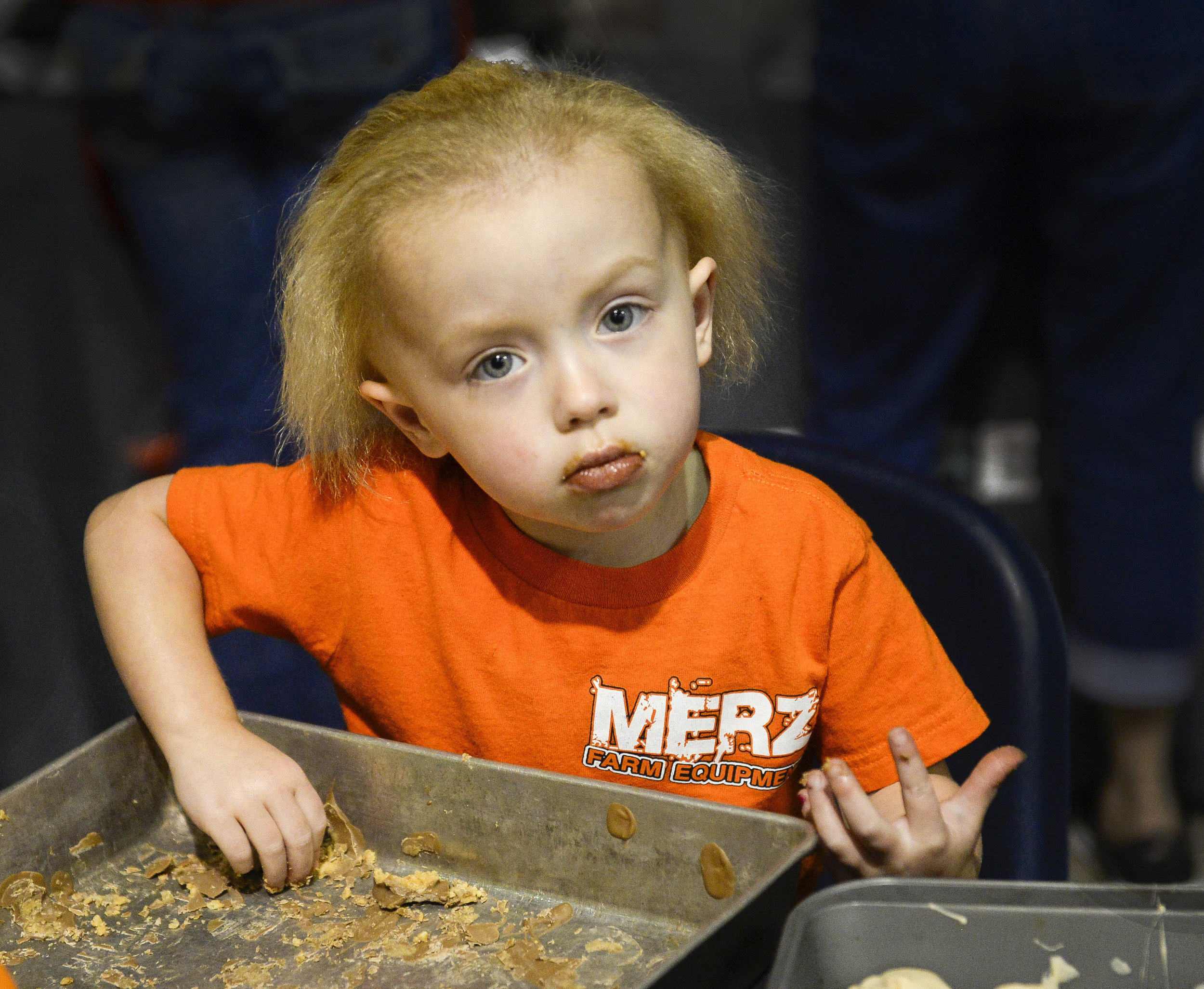   Natalie Witt, 2, finishes off a pan of leftover peanut butter and rice crispies used in making peanut butter bacon balms for the dessert recipe contest. Witt was there with Merz Farm Equipment who came from Fall City, Neb. to participate in the Bac