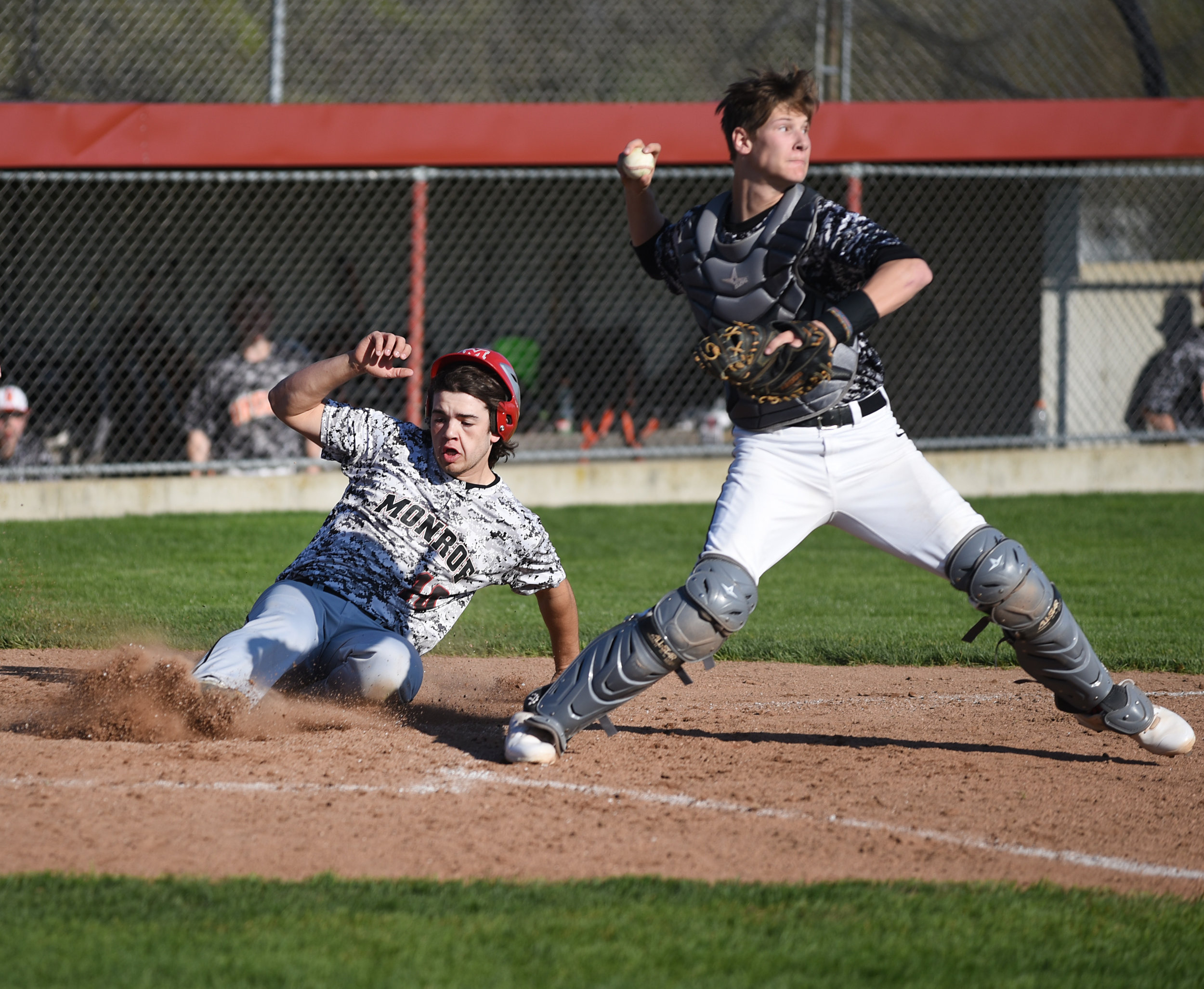 Monroe senior Hogan Edwards slides into home behind Oregon senior catcher Jack Haufle during a game against Oregon at Monroe High School May 5, 2017. 