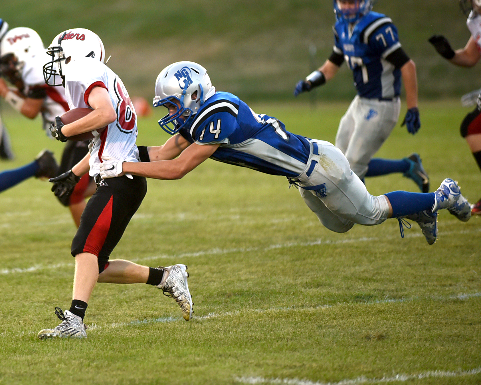 Edgerton junior Jackson Erickson is grabbed by New Glarus-Monticello senior Nick Santamassino during their game in New Glarus August 21, 2015.