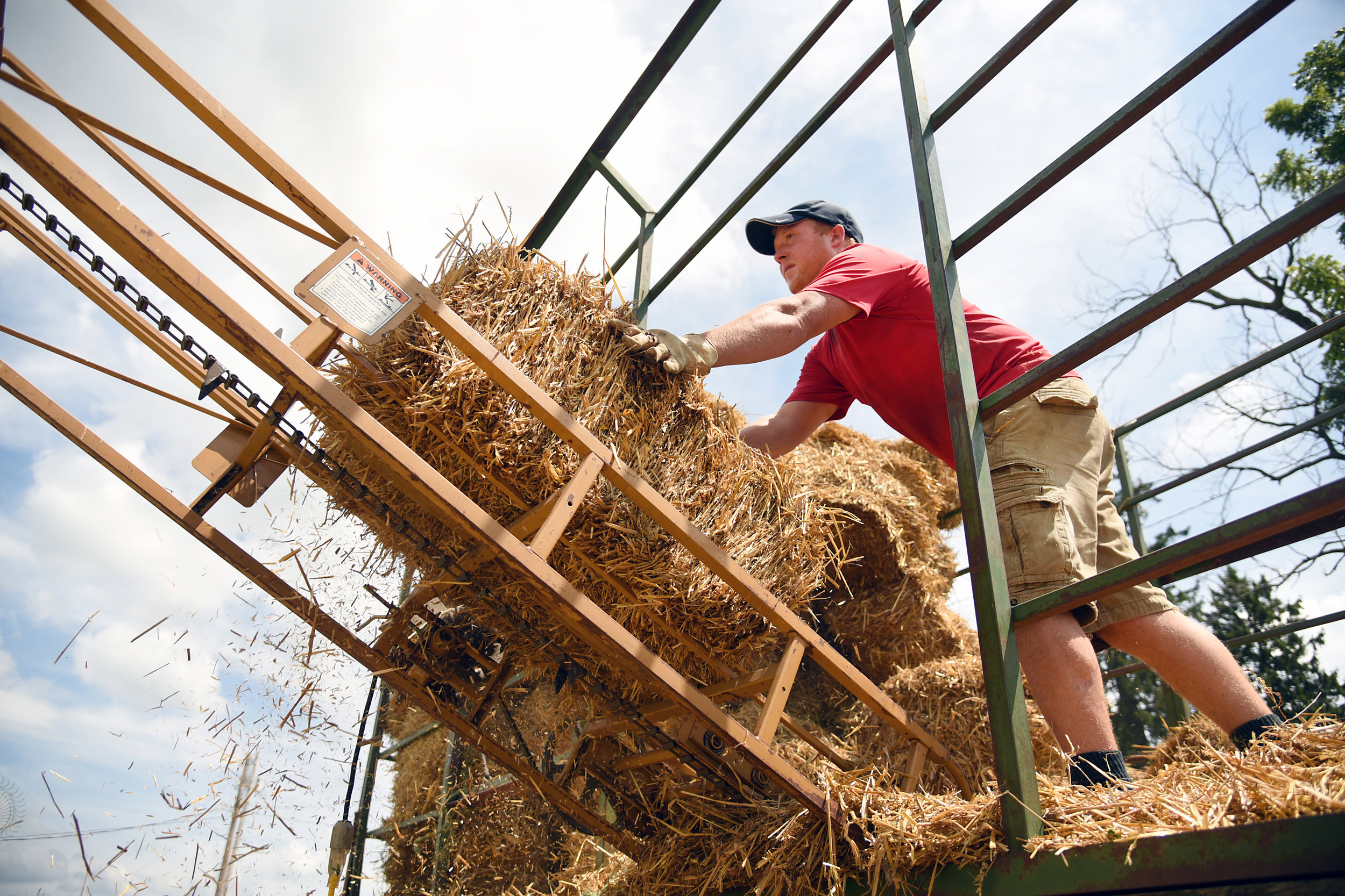 Scott Timm loads baled wheat straw at his family's farm outside of Monroe July 27, 2016. Timm works full time at his family's farm and owns his own seed company.