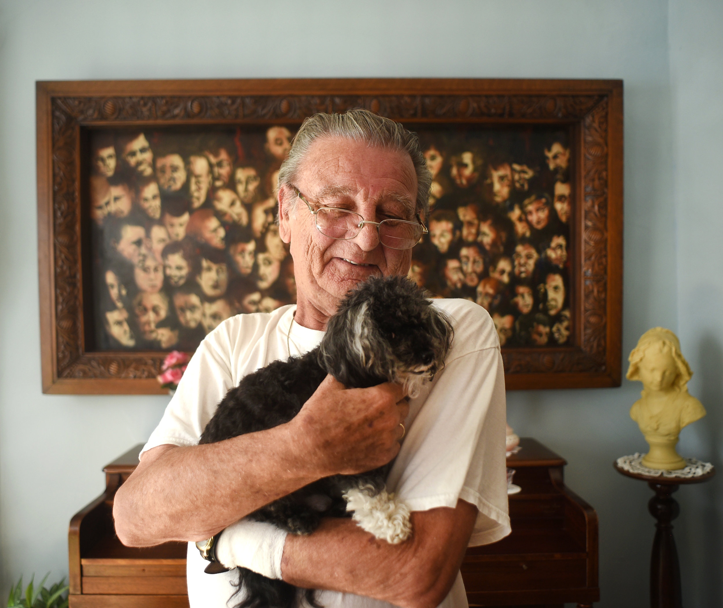 Robert Verdonck, a Flemish painter, holds his dog, Tobias, a nine-year-old teacup poodle and shihtzu mix, in front of one of his paintings in his home July 7, 2016. "When I'm painting," Verdonck said, "I feel like I'm in my own kind of world."