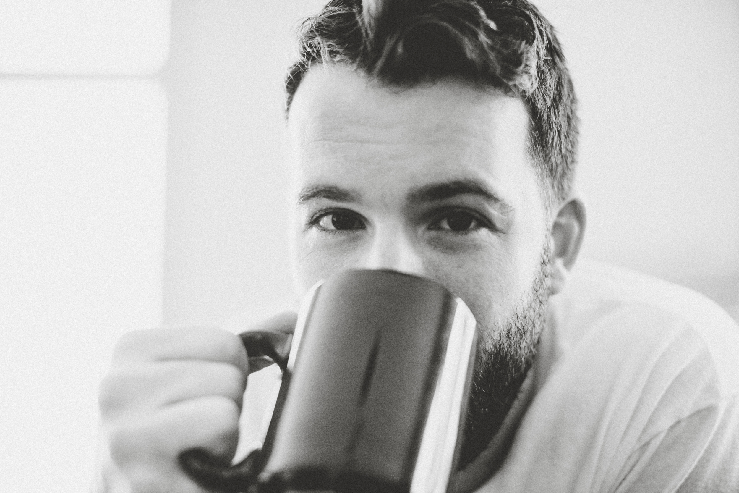 Daniel Alkato holding coffee mug black and white