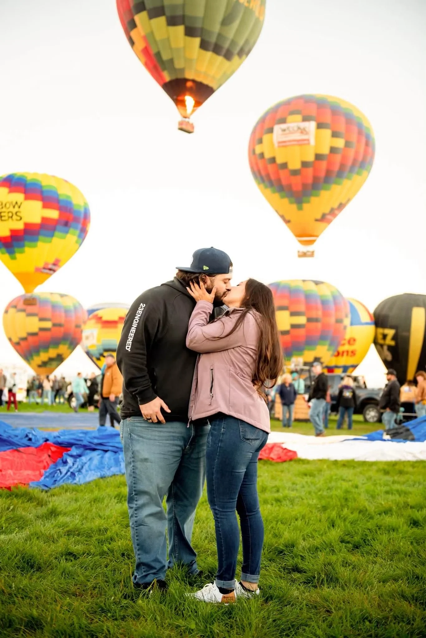 Couple kissing beneath hot air balloons at the Albuquerque International Balloon Fiesta