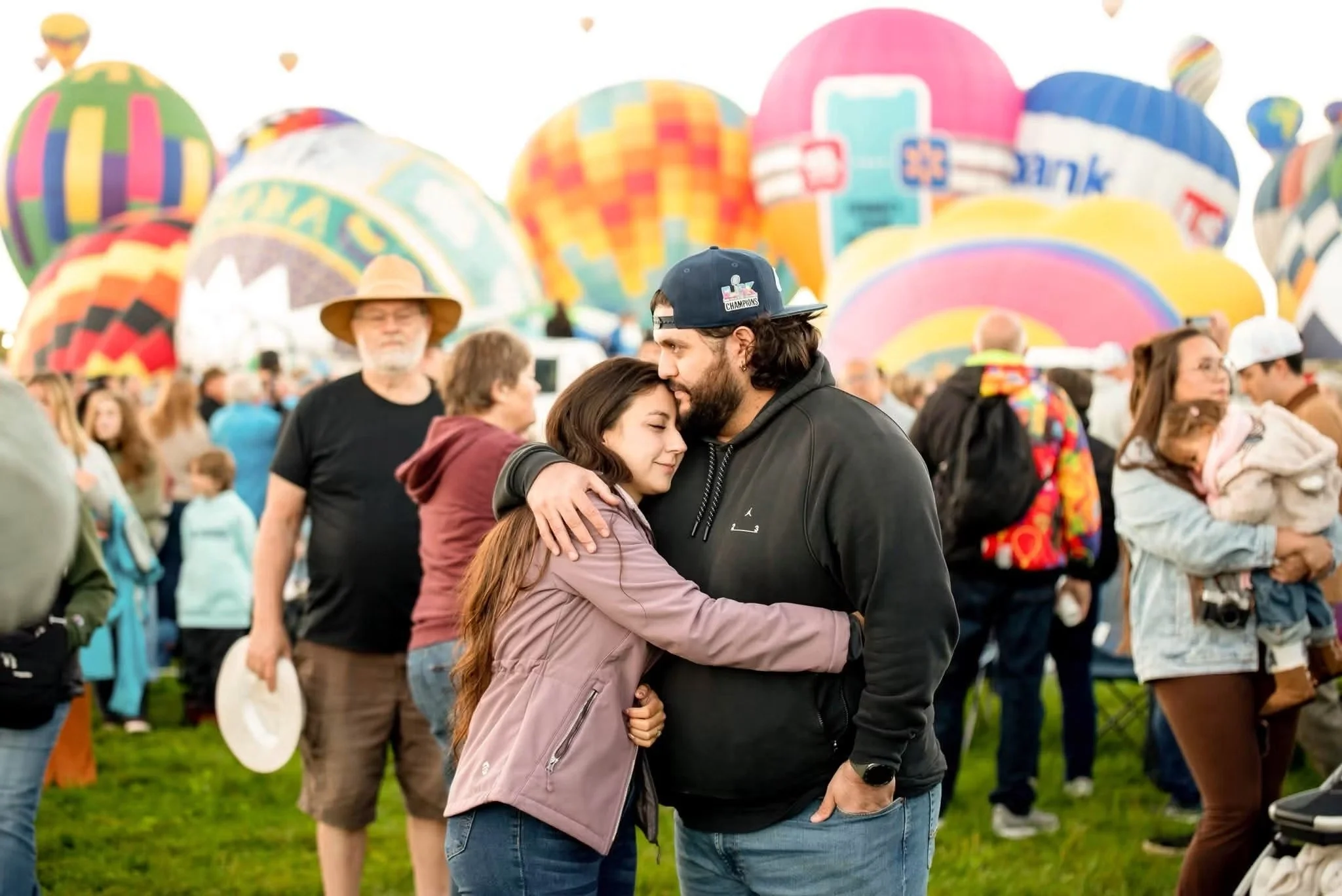 Engaged couple embracing among colorful balloons at Balloon Fiesta Park