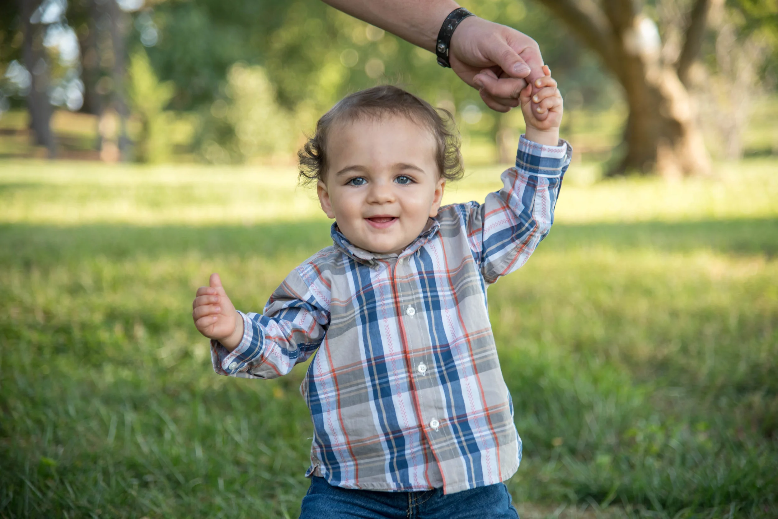 Boy holds his dads hand at shoot in St Louis