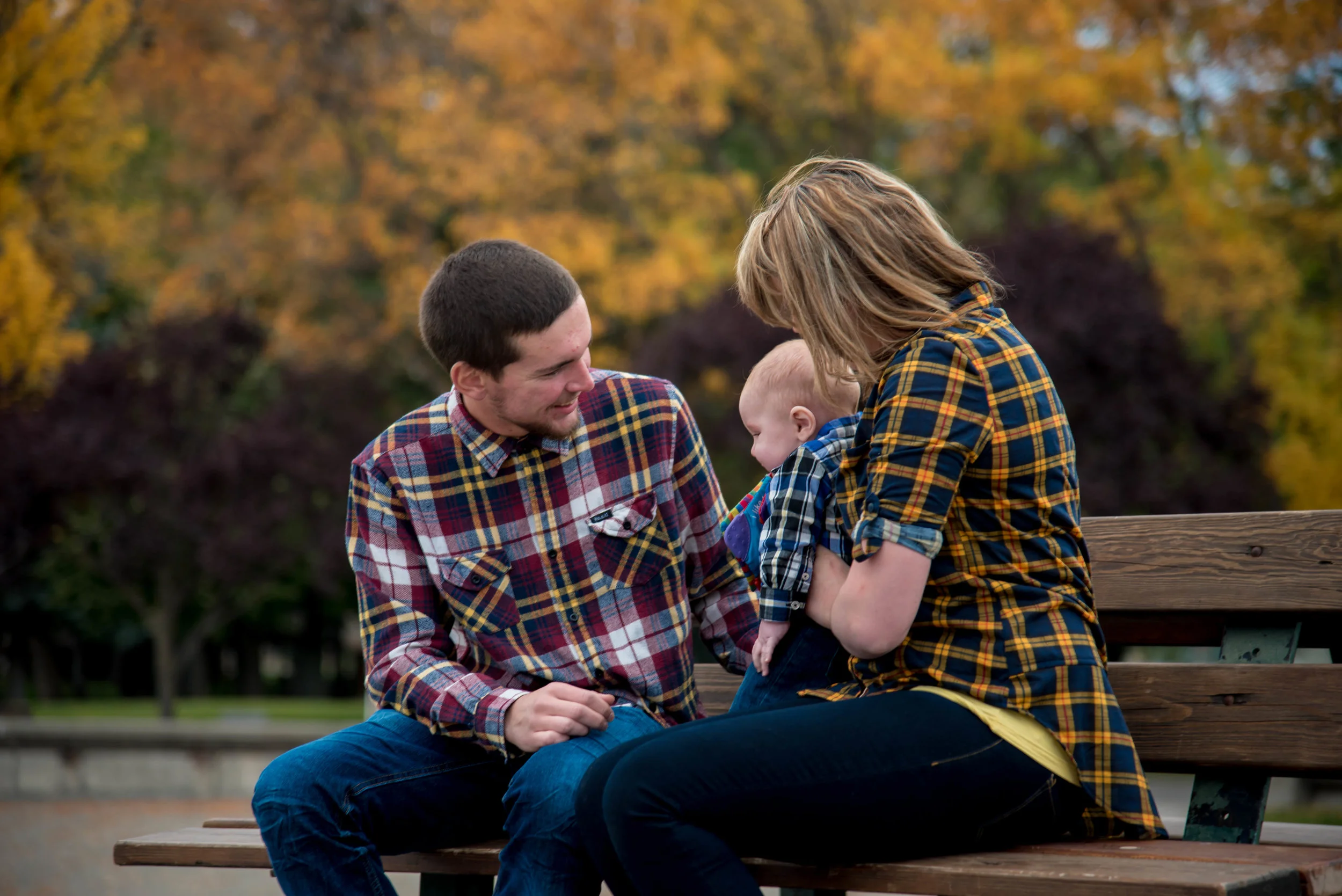 Boy smiling at baby on bench in Coeur d' Alene Idaho