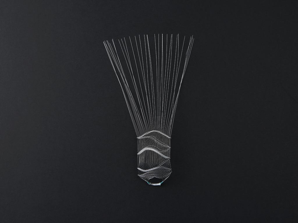 The projections of the wires that emerge from the ring interact with the light, shining bright of an extravagant splendour, as a peacock spreading its tail.