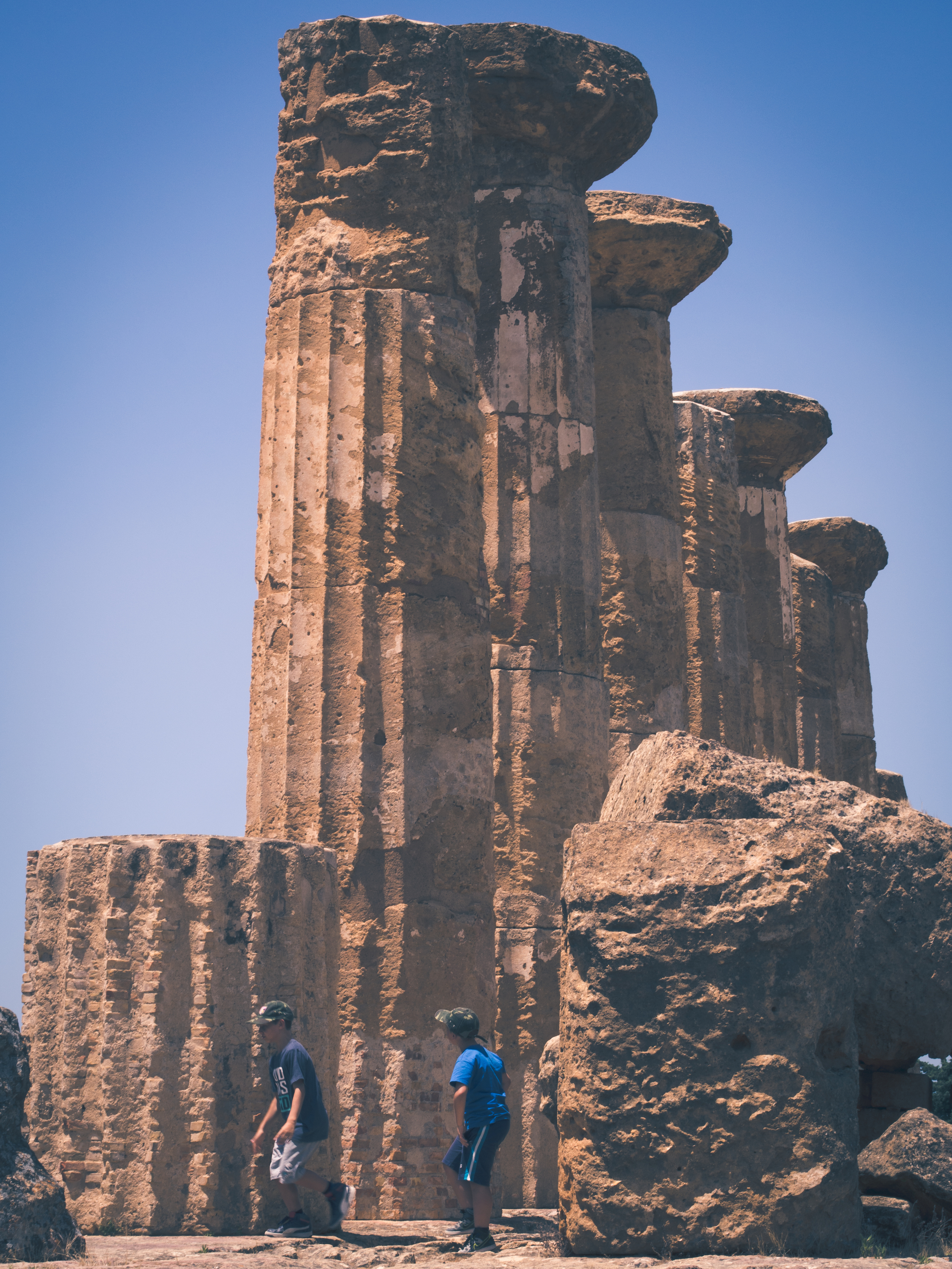 Two kids play around the Greek Temple ruins.