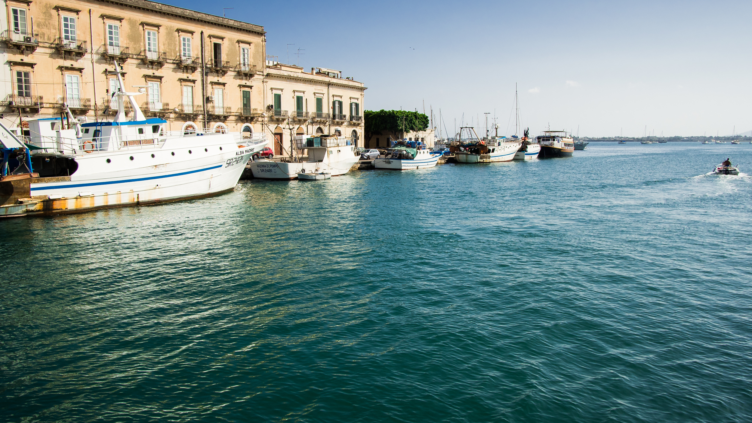 There is a small waterway between mainland Sicily and the island of Ortigia where there are many small boats tied up. The bay created between the island and the sea is quite large and many luxury yachts can be seen enjoying its calmer waters.
