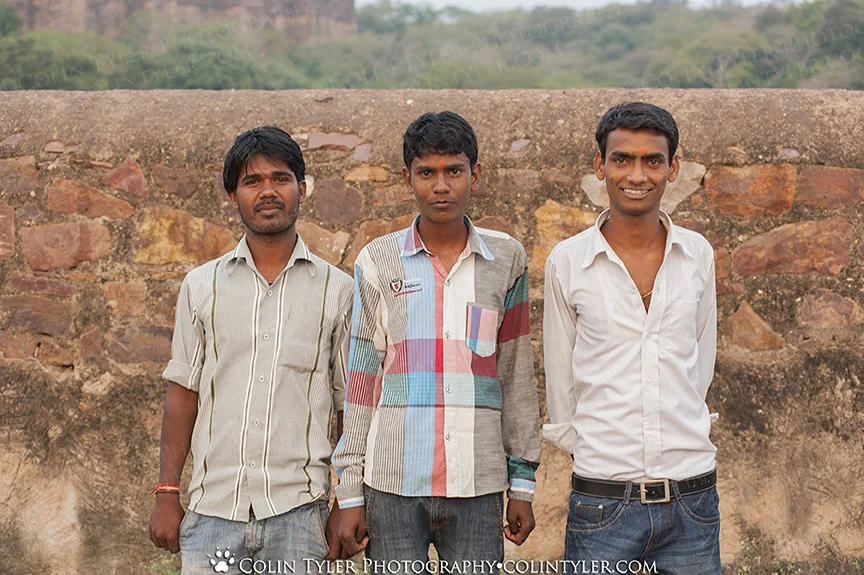 Three young men posed for a group photo at a Hindu religious festival at the Ranthambore Fort, India