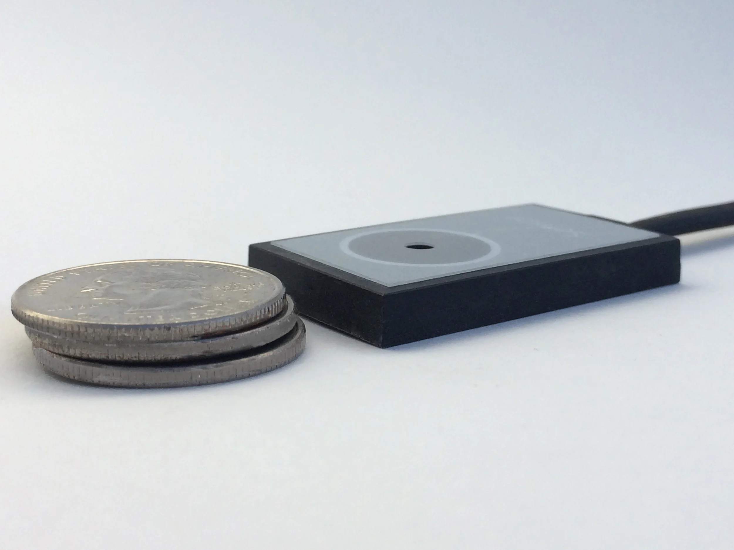 The sensor is designed to be as thin as possible for use with a vacuum frame or plate burner. It has a thin-flat cable intended to pass underneath the vacuum seal.