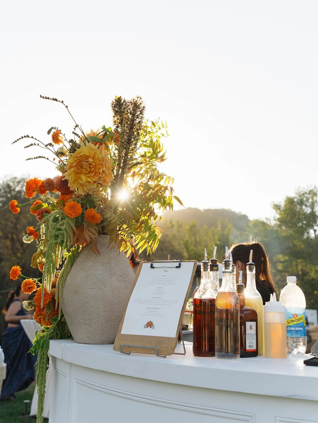 Might I suggest a 360 bar for your reception? Not only did it look VERY cool, it also gave guests plenty of space to gather and stay hydrated 🙃

Flower-wise, we anchored the space with one larger focal arrangement near the reception tent, then layer