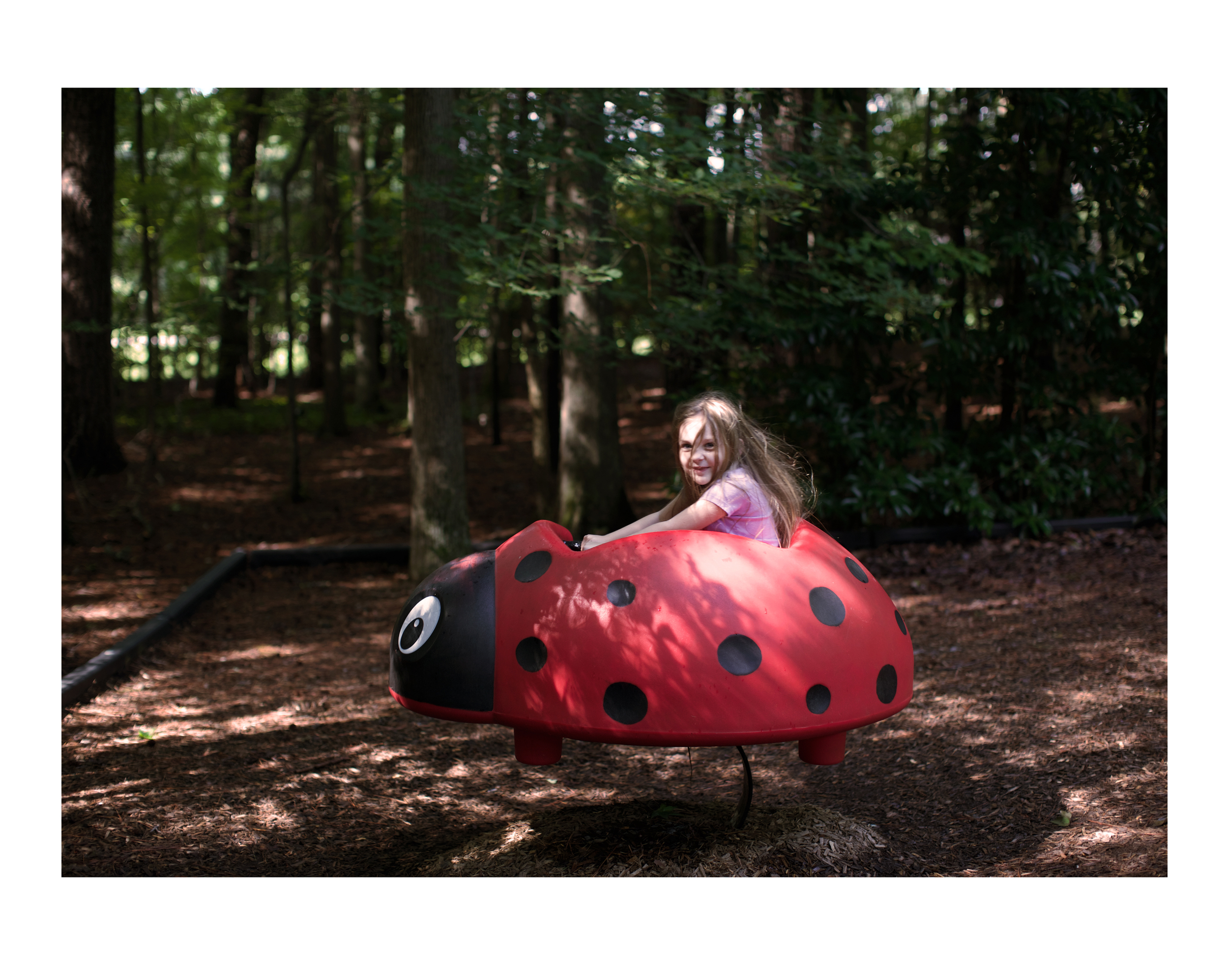 Karina riding the ladybug at Sandy Bottom Nature Park.