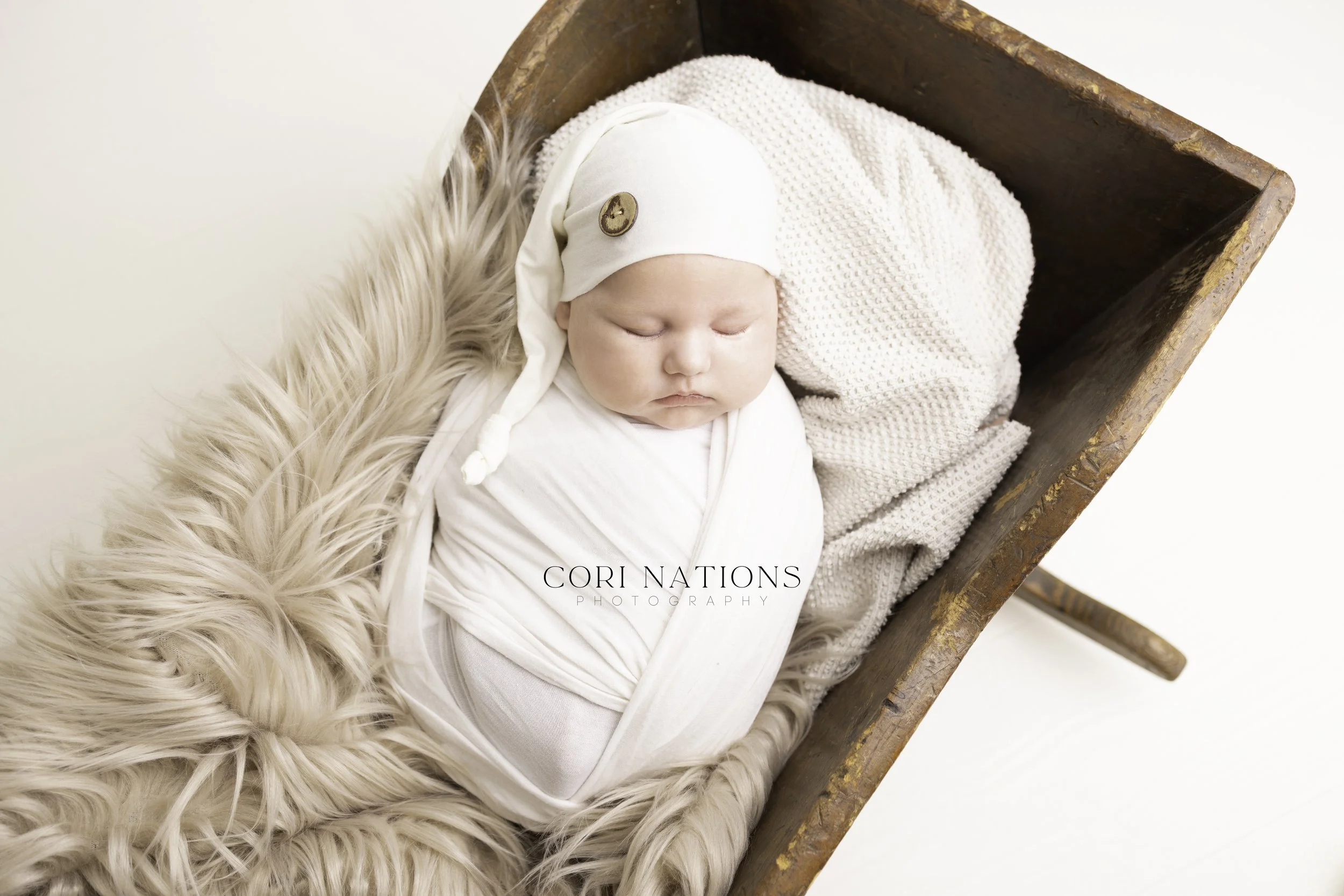 Newborn baby boy in vintage crib with fur and white blanket St. Louis, Missouri