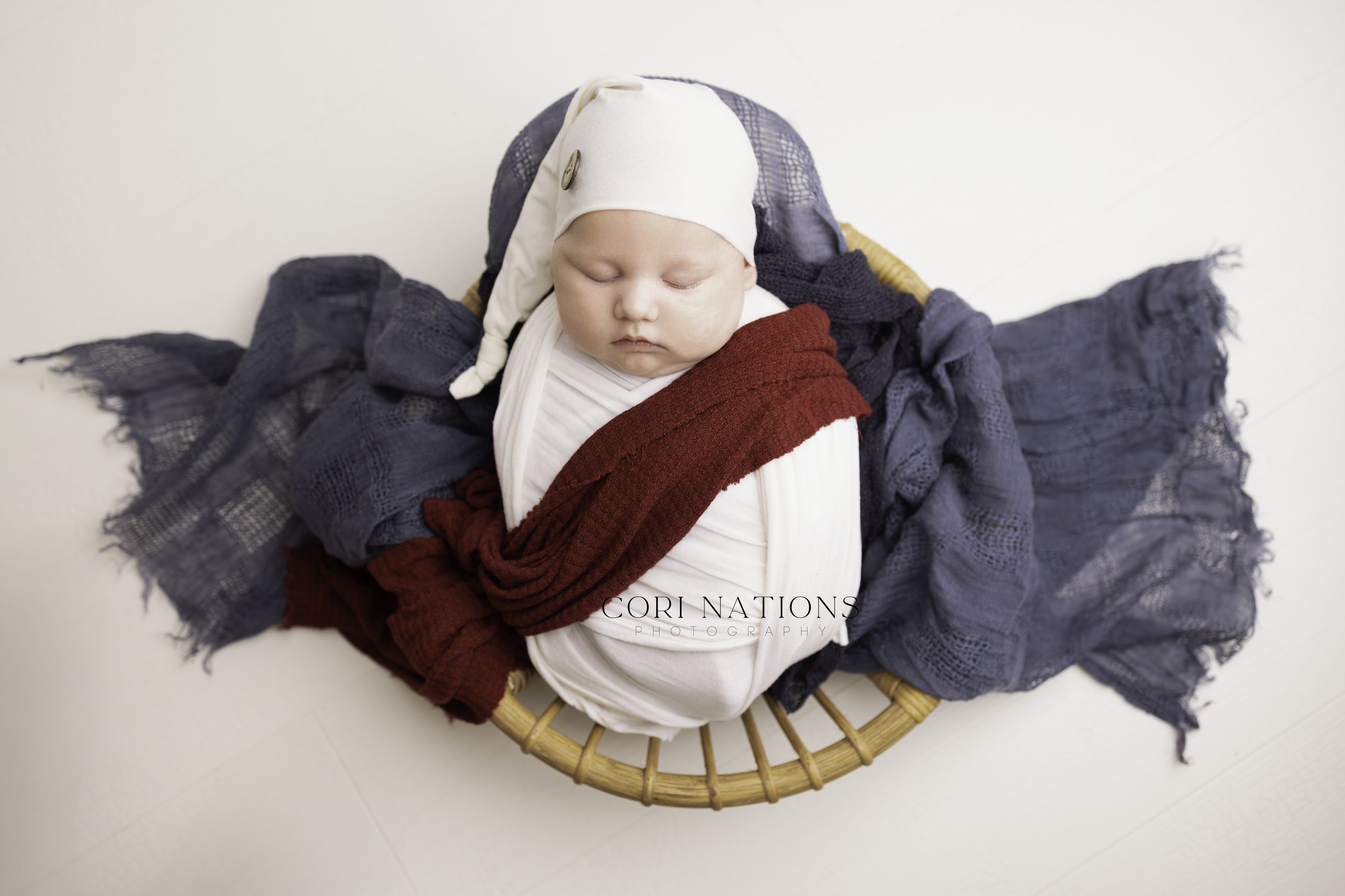 Newborn boy in basket with maroon sash St. Louis, Missouri