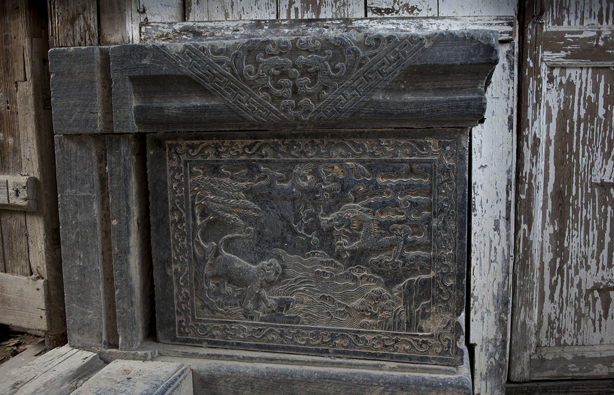   The stone carving of a tiger on an elaborate stone plinth peeking out from behind a wooden barricade is another sign the hall was built to honor a high-level official. With a burgeoning tourist industry, stone carving has again become a lucrative b